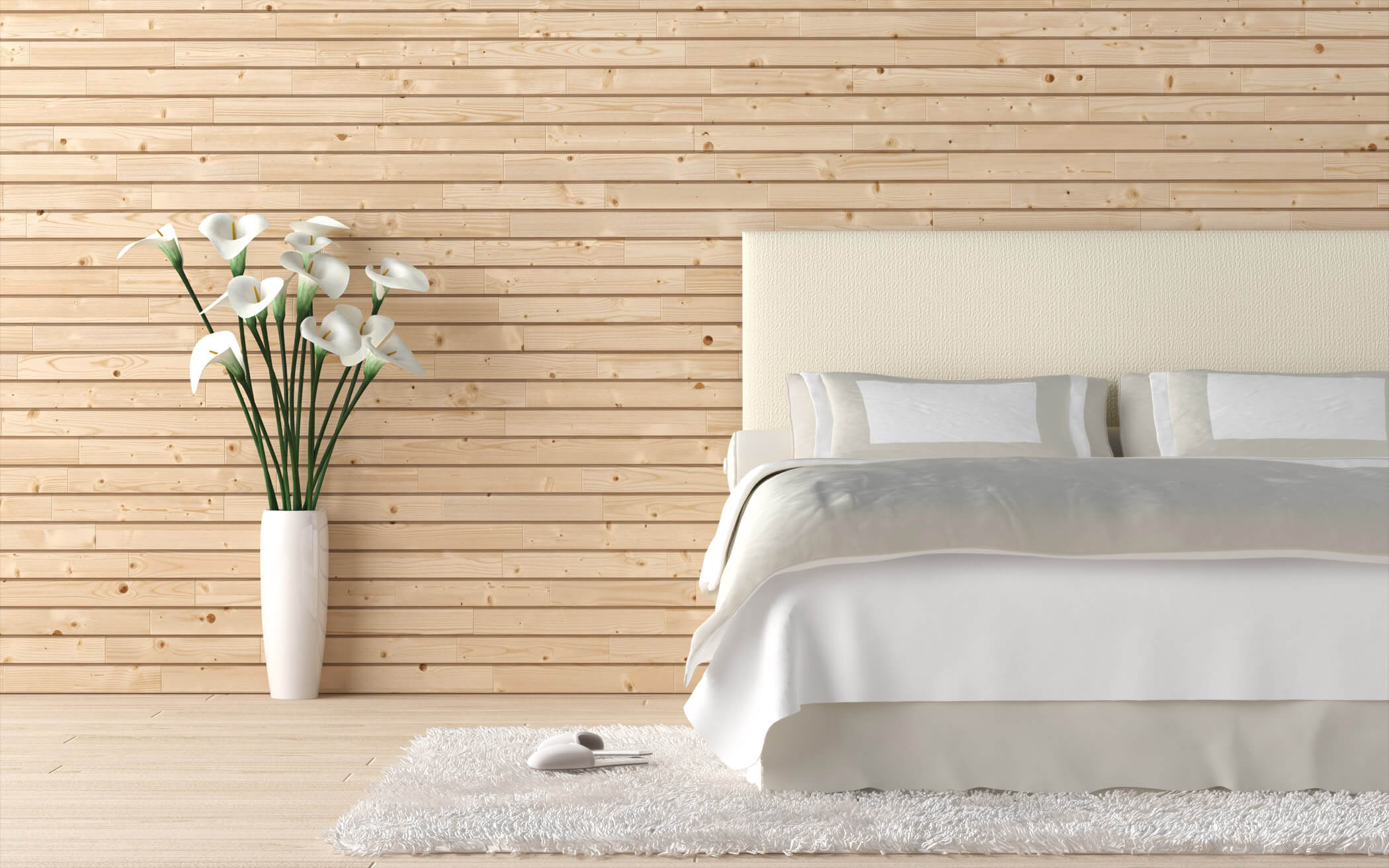 A white bed with bed linens in front of a wood panel wall