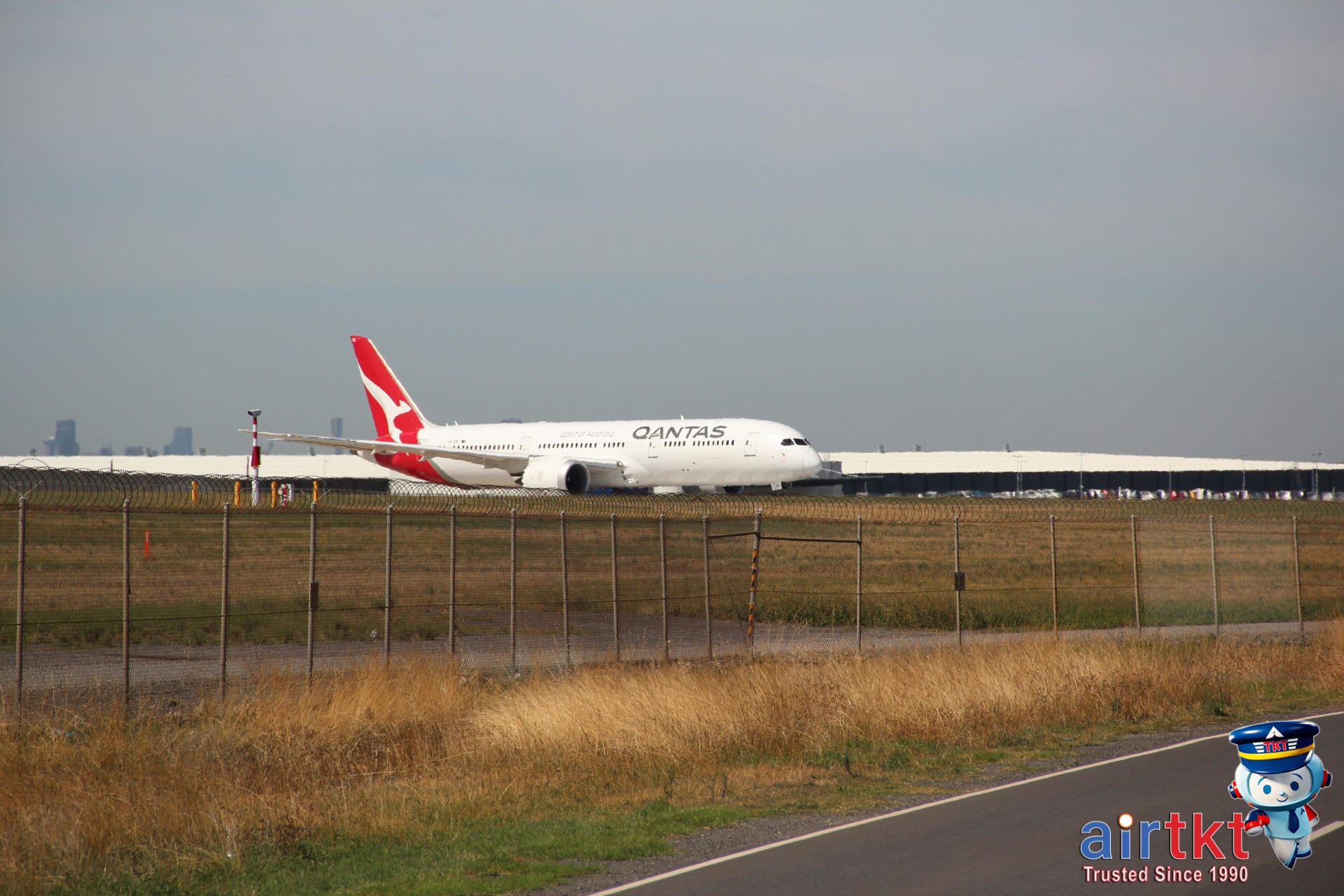 Qantas airplane on airport runway on clear day