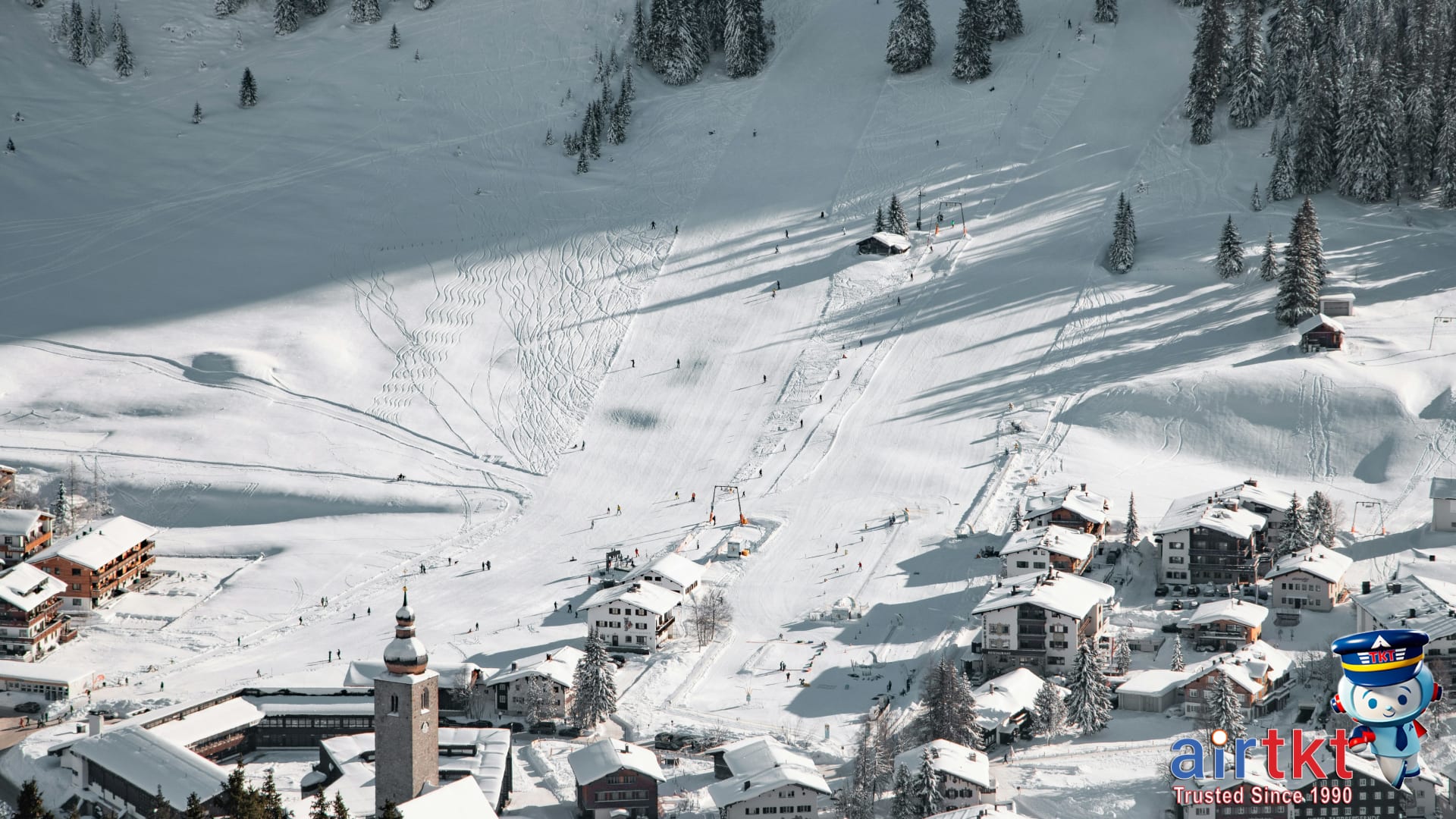 Apres-ski scene at Austrian ski village in winter with snow-covered slopes