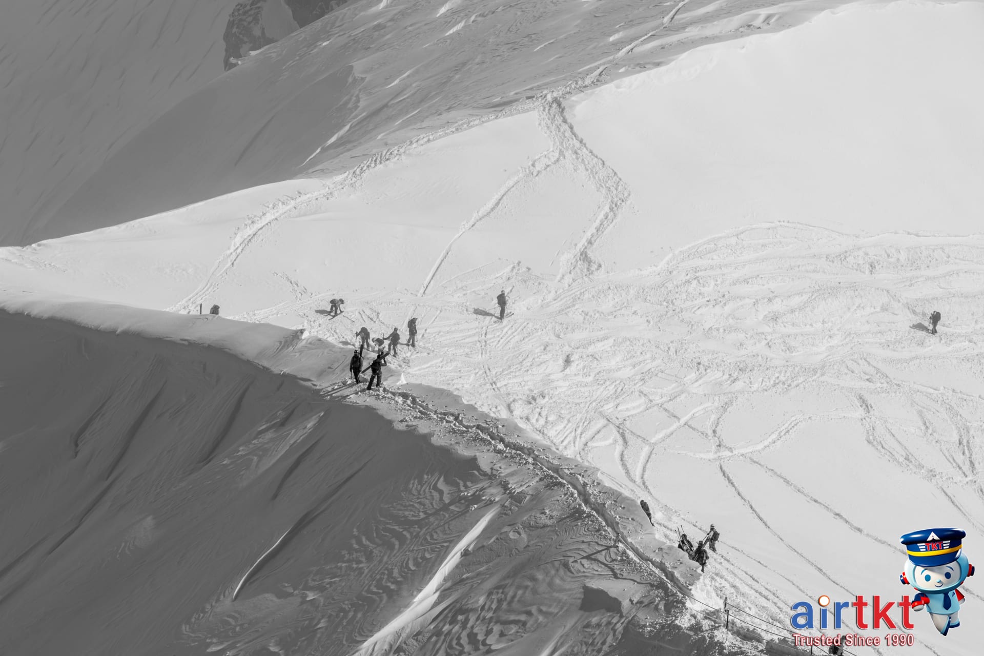 Skiers traverse a snow-covered mountain range in Chamonix, France, under clear skies