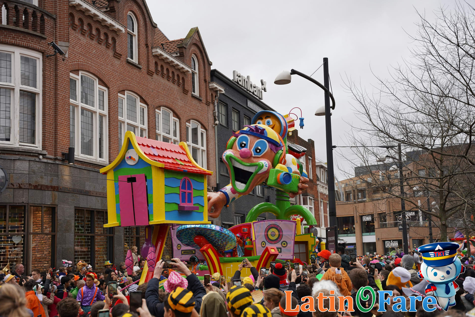 Crowded street with colorful Mardi Gras parade floats and costumed crowd enjoying festivities