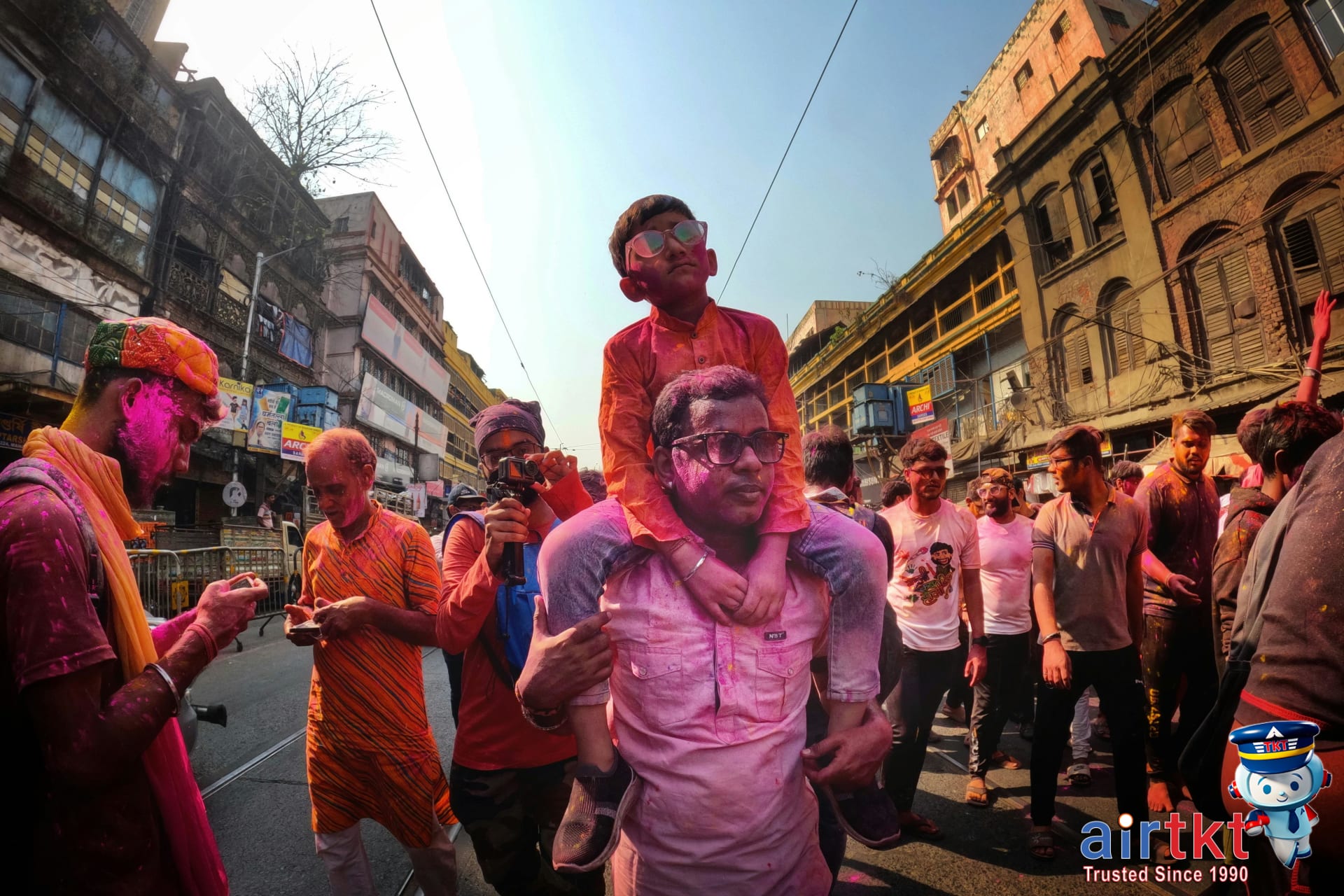 Vibrant street Holi celebration with people covered in colors in Kolkata