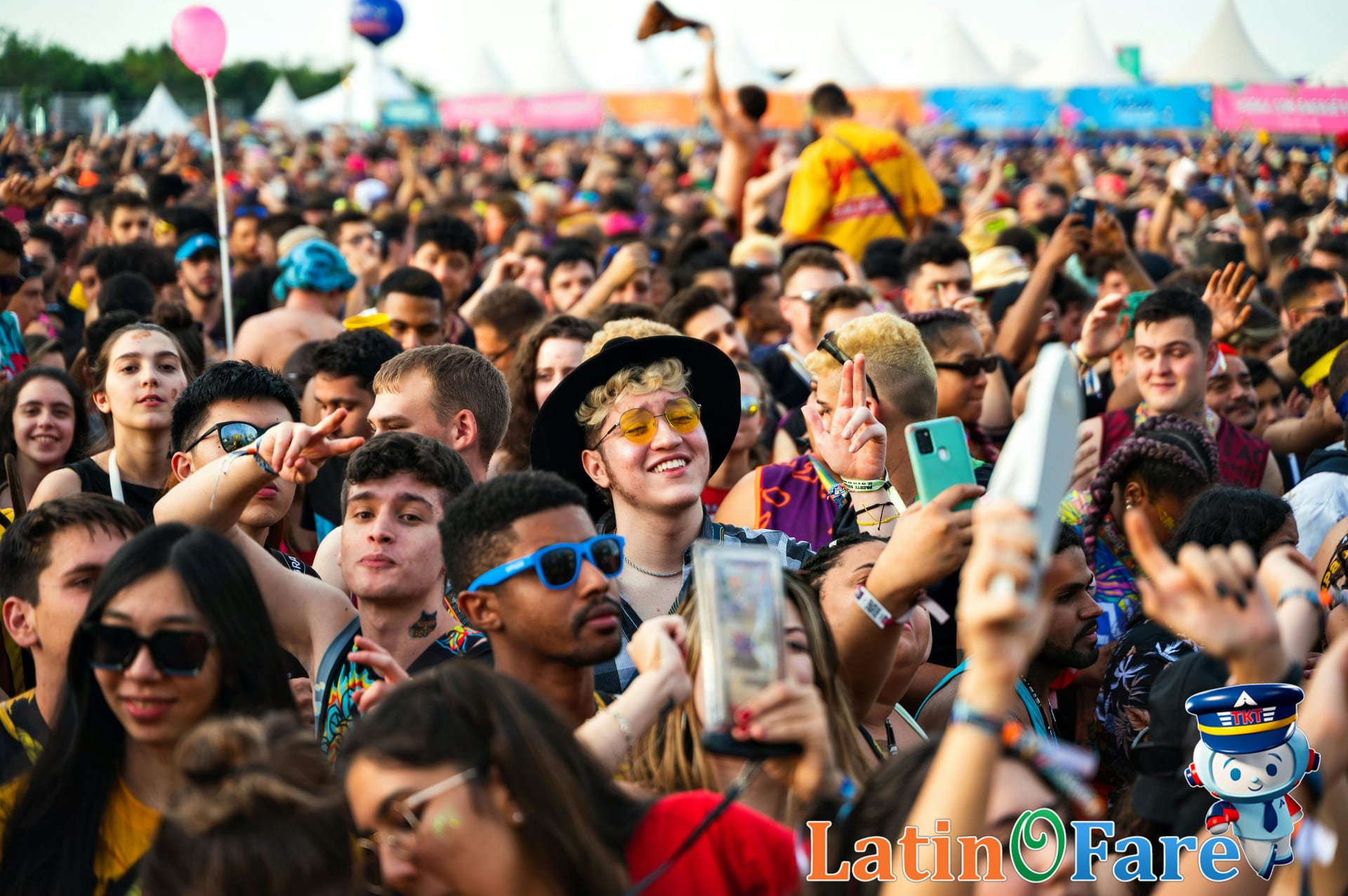 Coachella festival main stage at night with crowd in festival outfits enjoying live music.