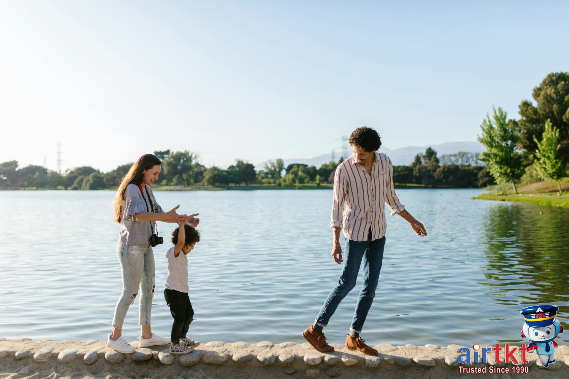 Joyful family enjoying quality time walking by a scenic lake on sunny spring day