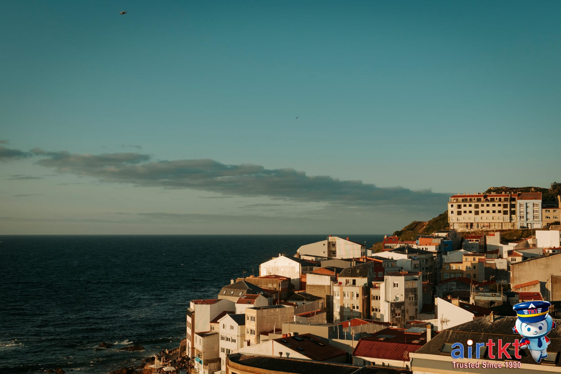 Scenic coastal town with vibrant buildings along the ocean shore in April spring break