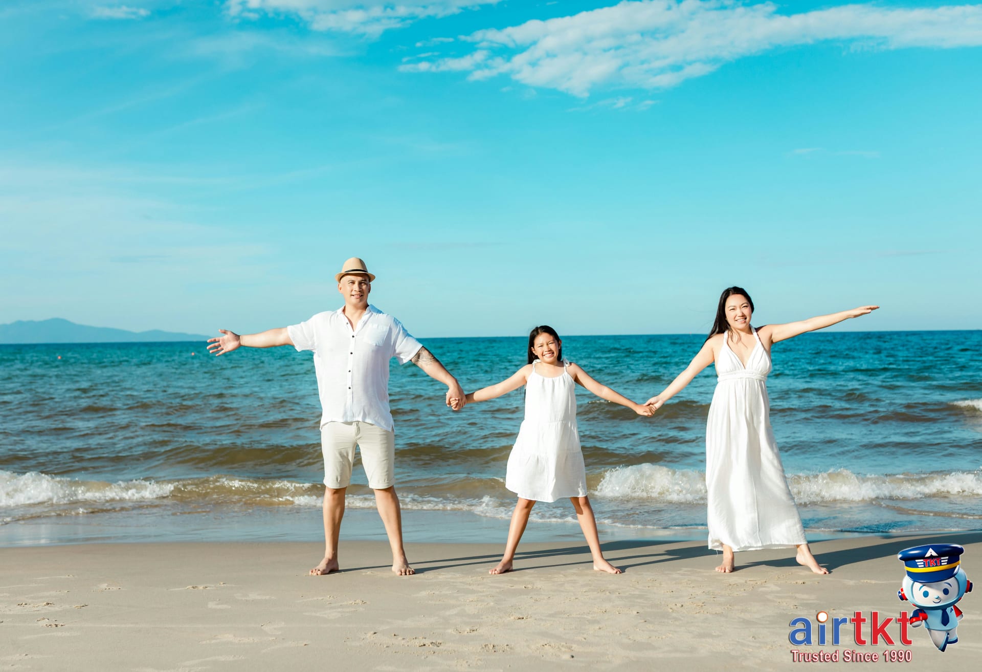Happy family holding hands on a sunny beach in Hoi An for April spring break