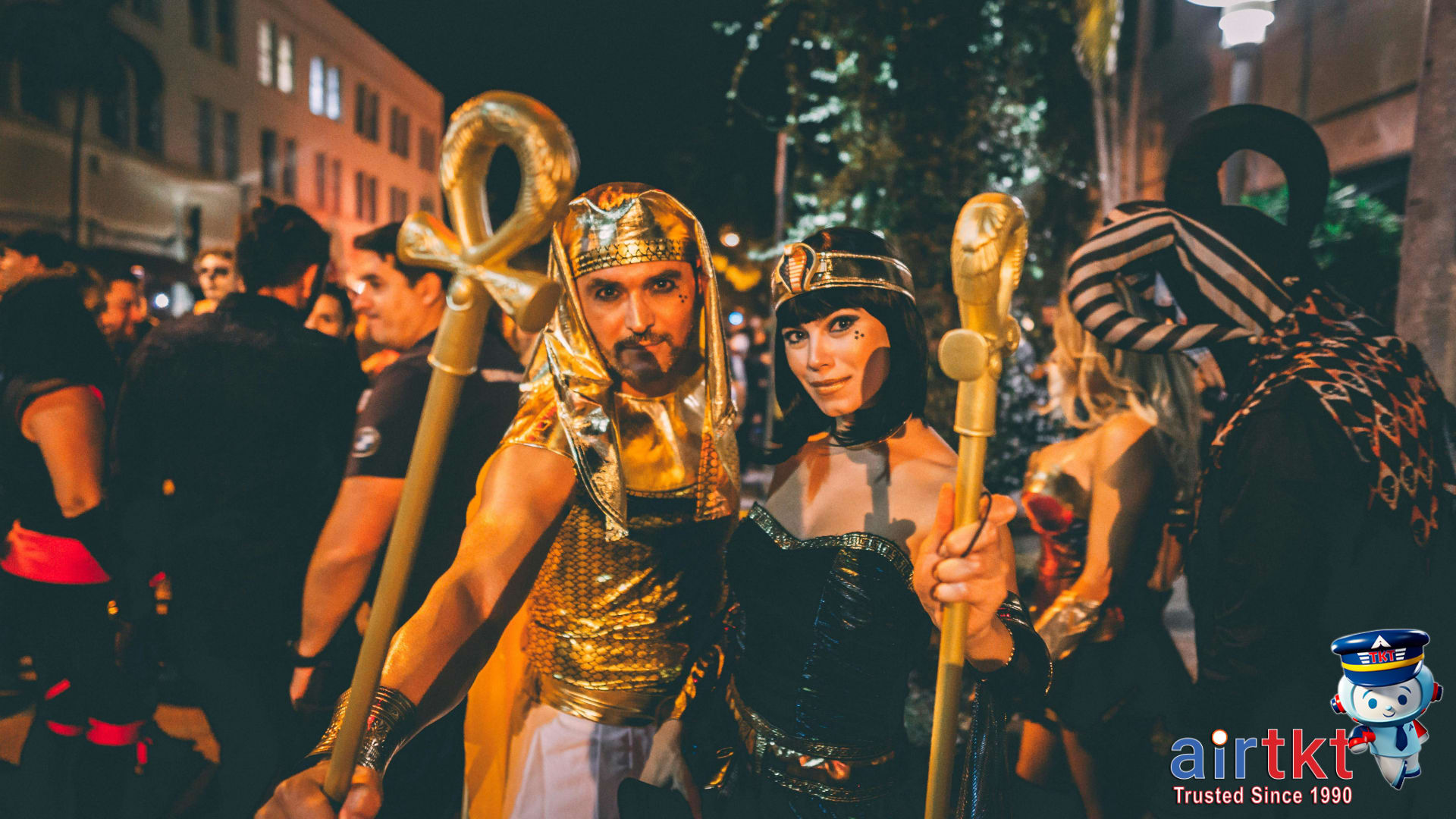Festival-goers celebrating Fat Tuesday at New Orleans street party surrounded by floats and musicians