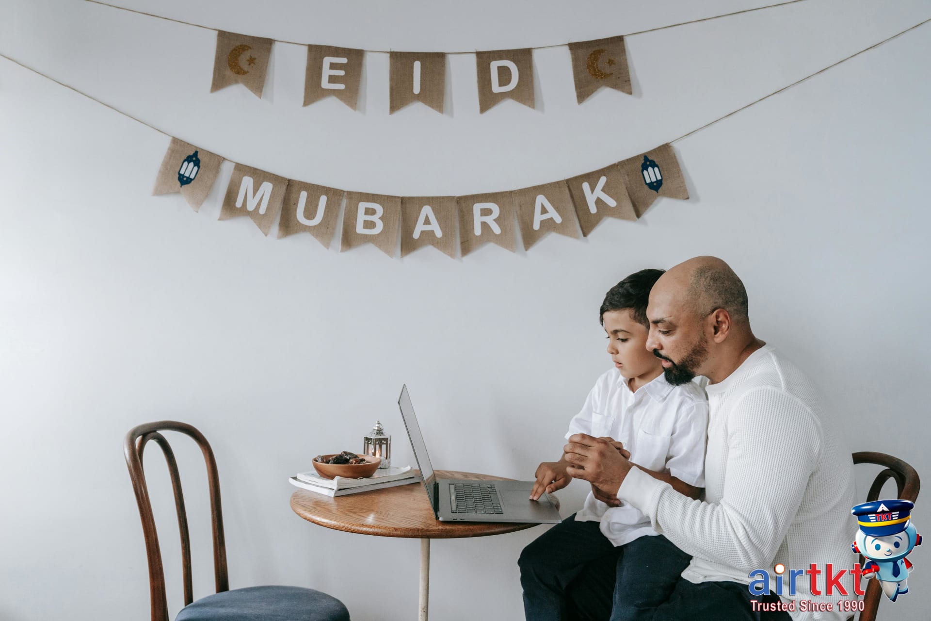 Booking Eid al-Adha travel on AirTkt platform on laptop at home, showing search results