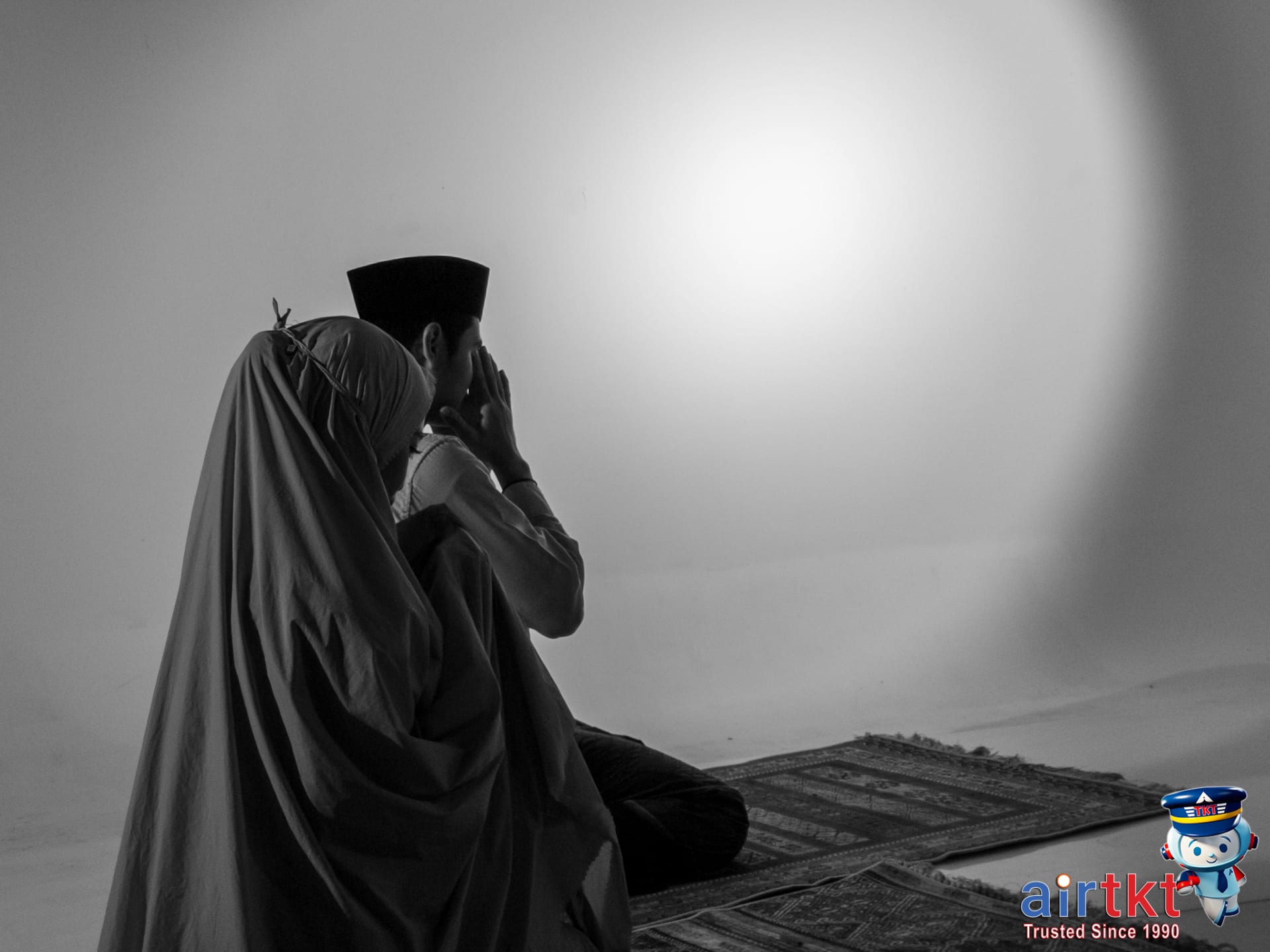 Muslim couple praying together indoors for Eid al-Adha travel planning