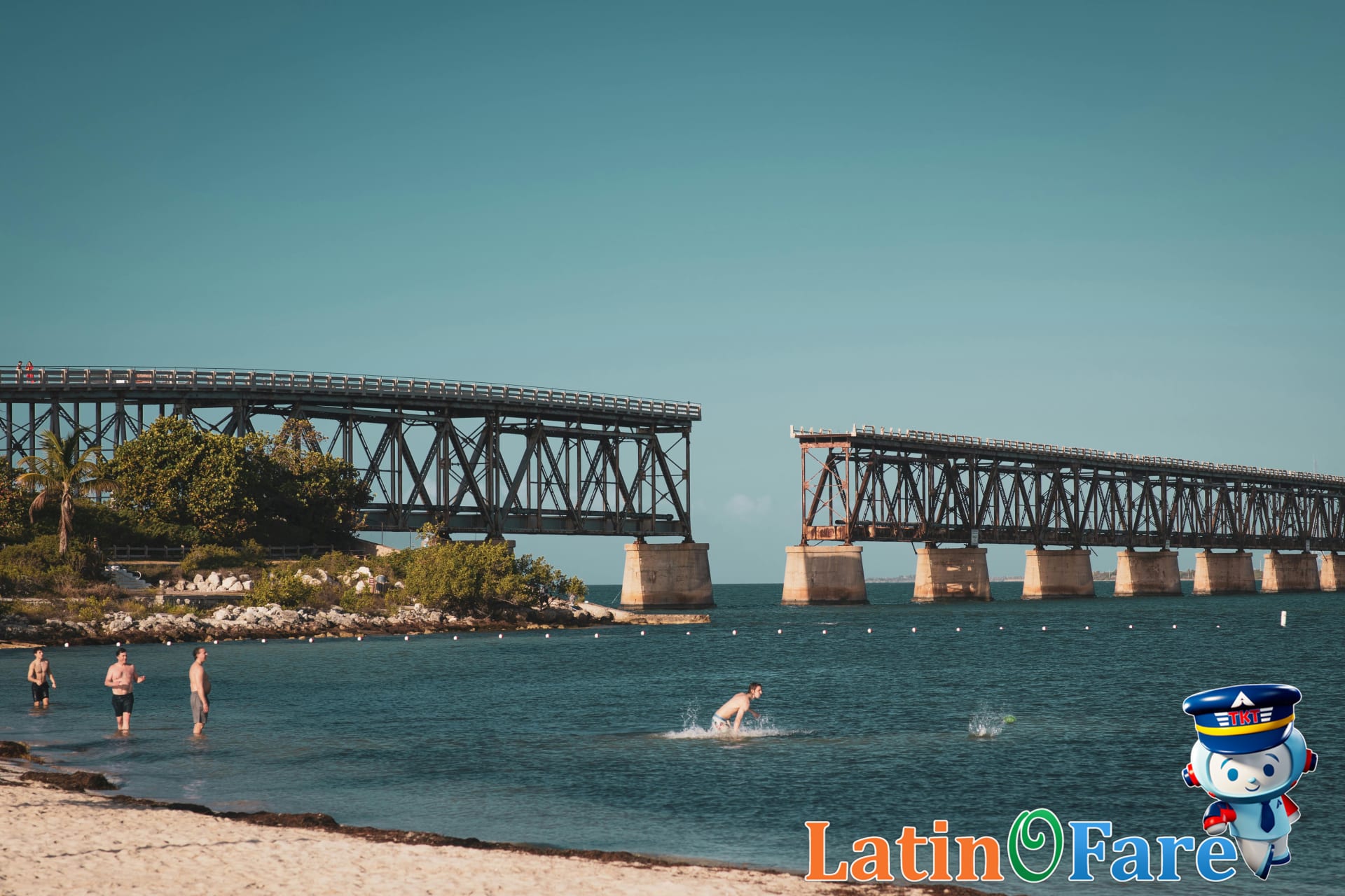 Bahia Honda beach with swimmers in clear shallow water, palm trees, and pristine Florida Keys shoreline.