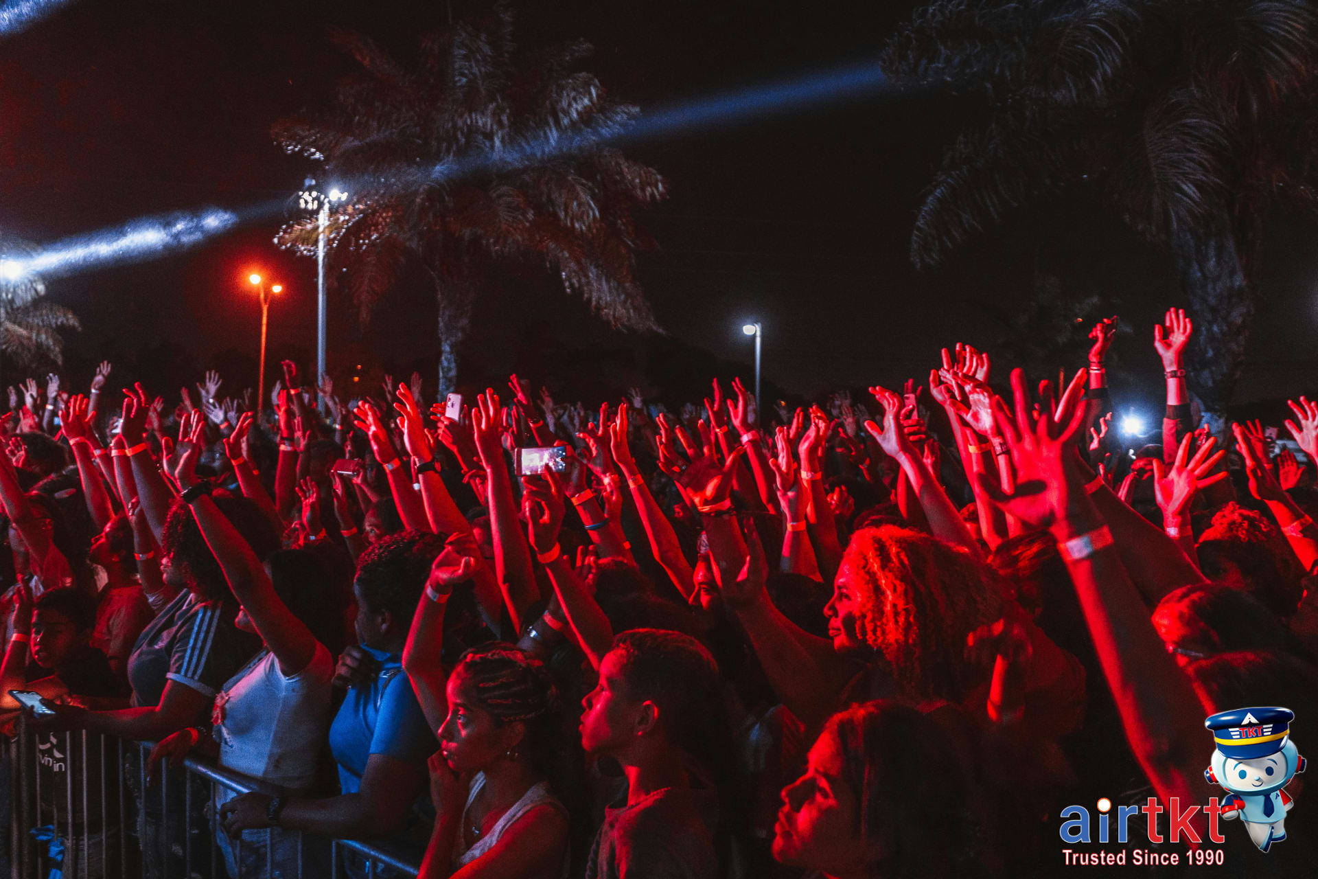 Festival crowd enjoying live music performances under palm trees at Coachella
