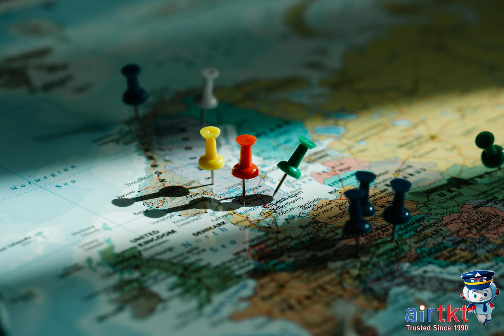 Colorful push pins marking different locations on a world map highlighting flight price regions