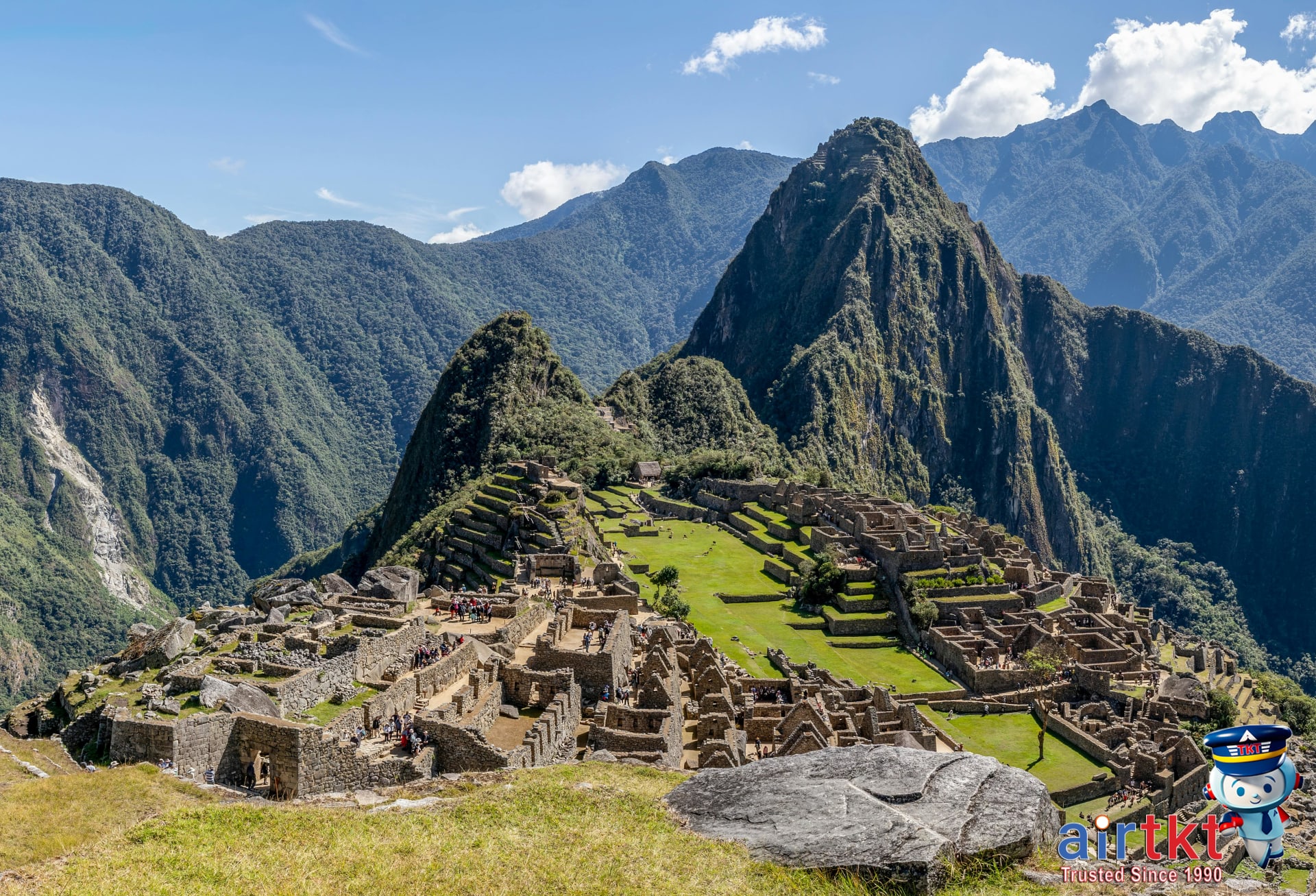 Backpackers visiting Machu Picchu on South America Gringo Trail, surrounded by lush mountains