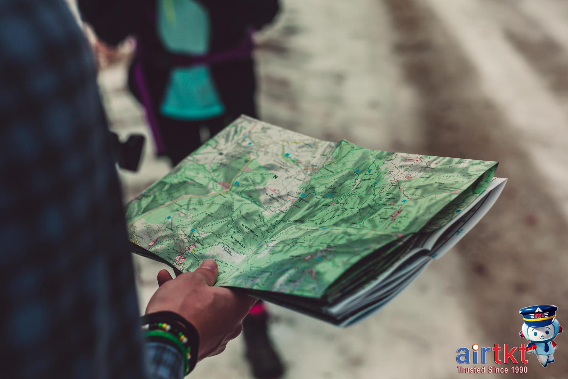 A person holding a detailed outdoor route map for South America backpackers