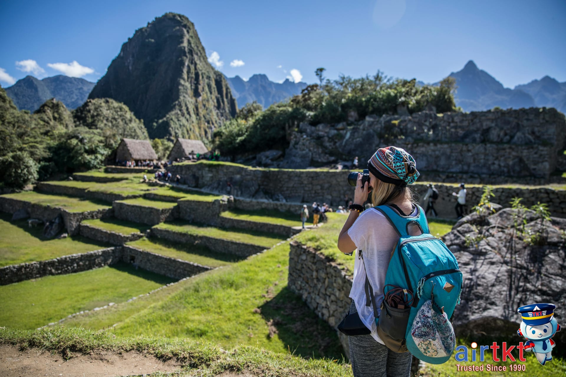 Travelers taking photos at Machu Picchu viewpoints with phones and cameras among ancient terraces and mountains