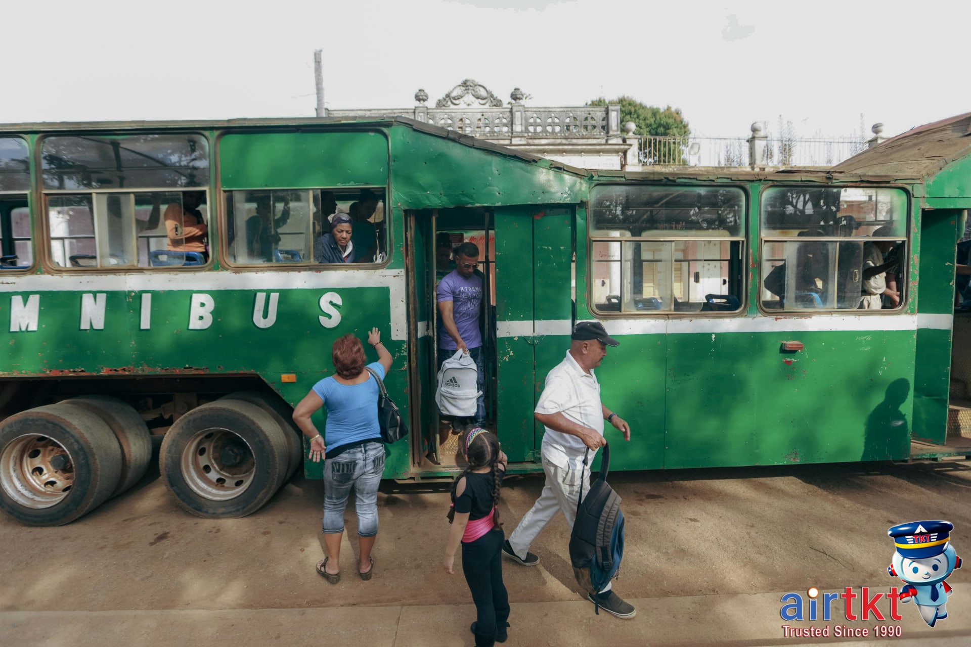 Tourists boarding Machu Picchu bus with mountain scenery in background