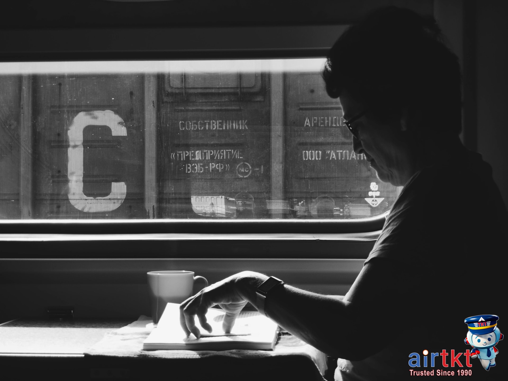 Woman reading a book on train ride, ideal for budget travel with Eurail pass
