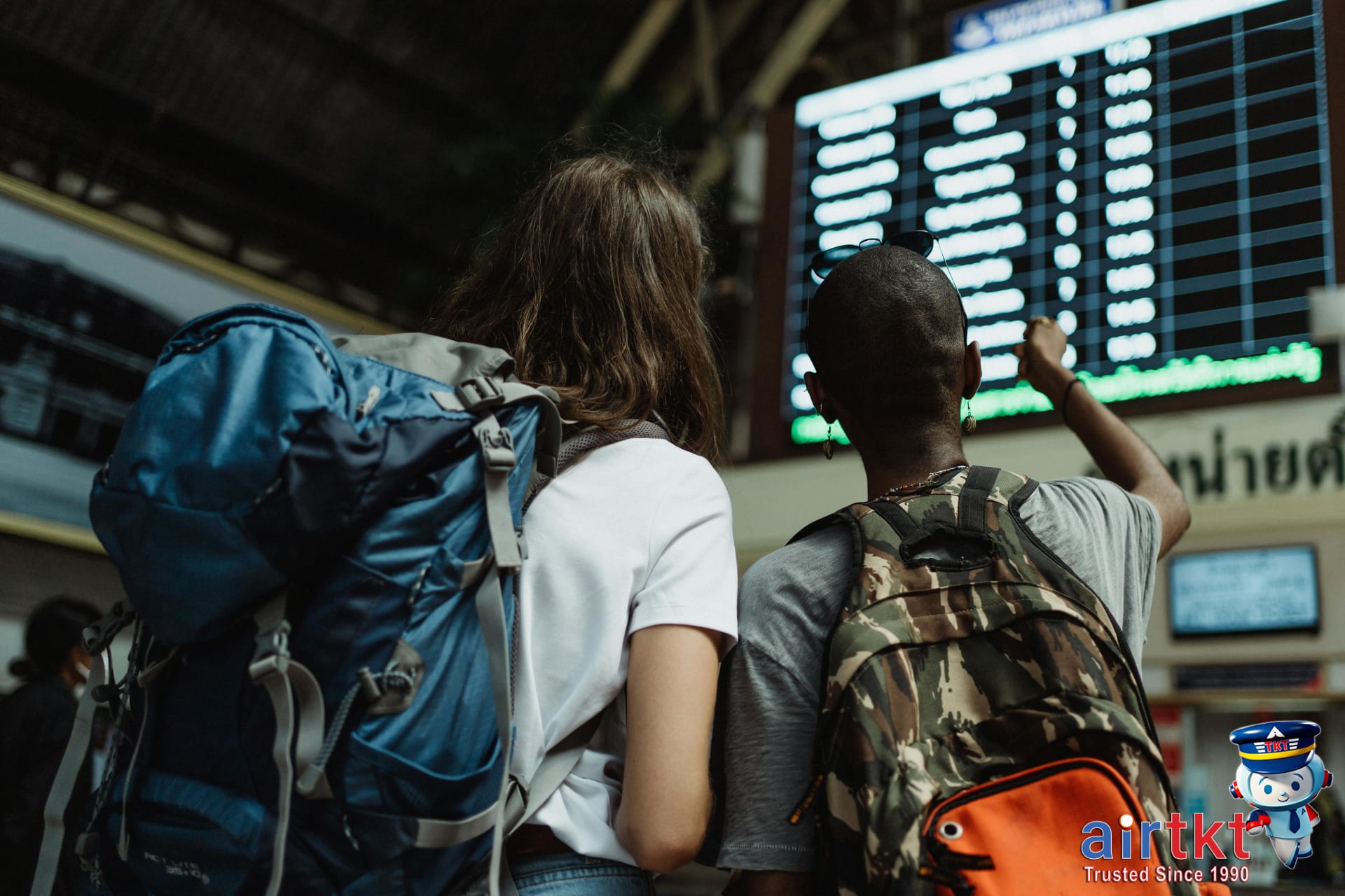 Traveler checking train schedule on digital board showing Eurail pass limitations