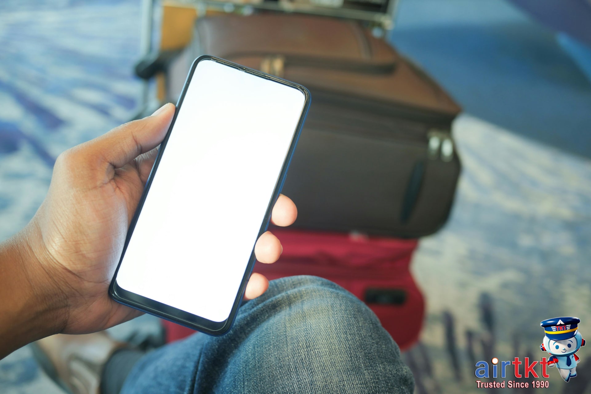 Traveler checking smartphone for cheap flight prices with luggage