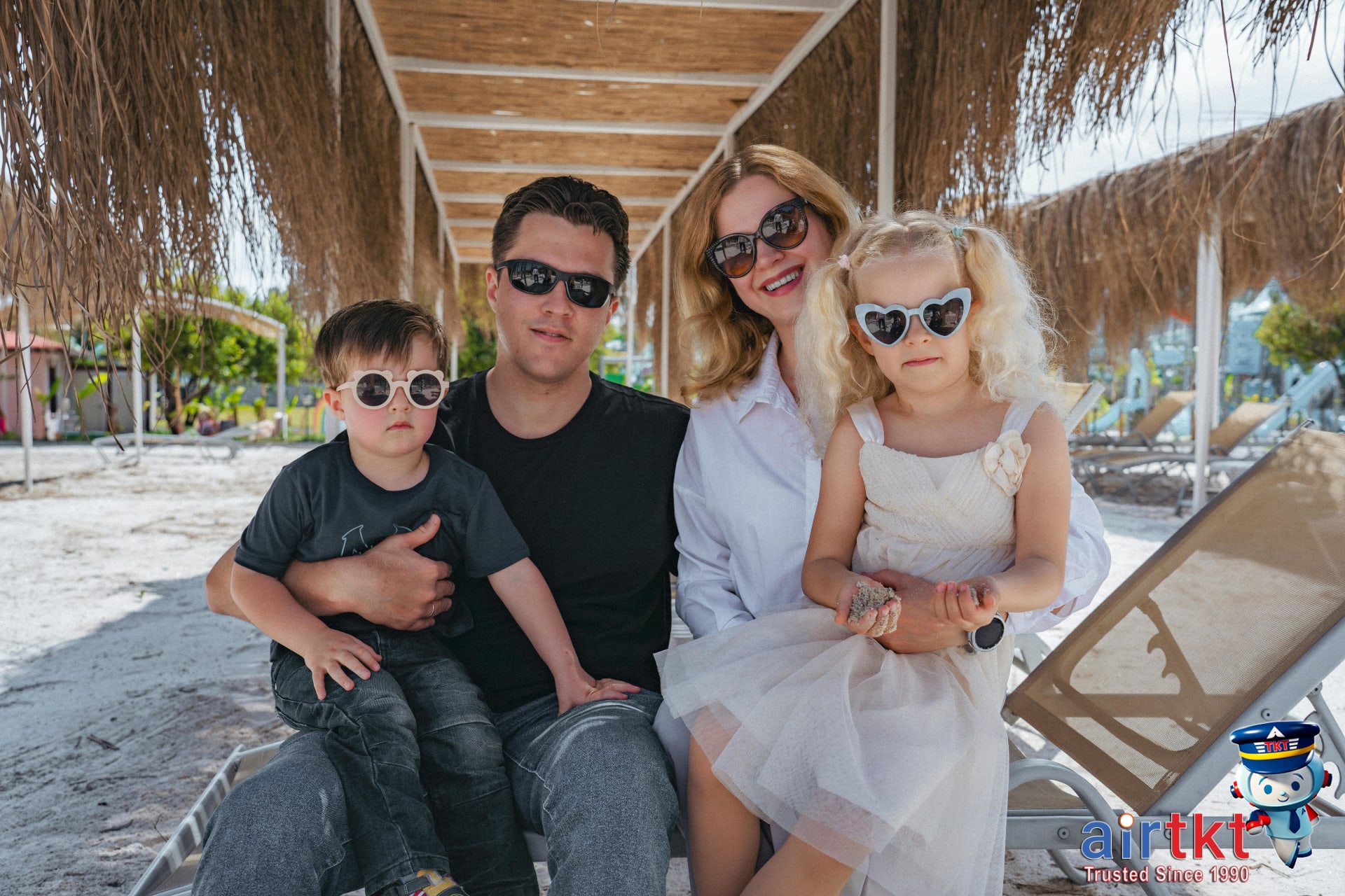 Family wearing hats and sunglasses at the beach following summer travel safety tips in July