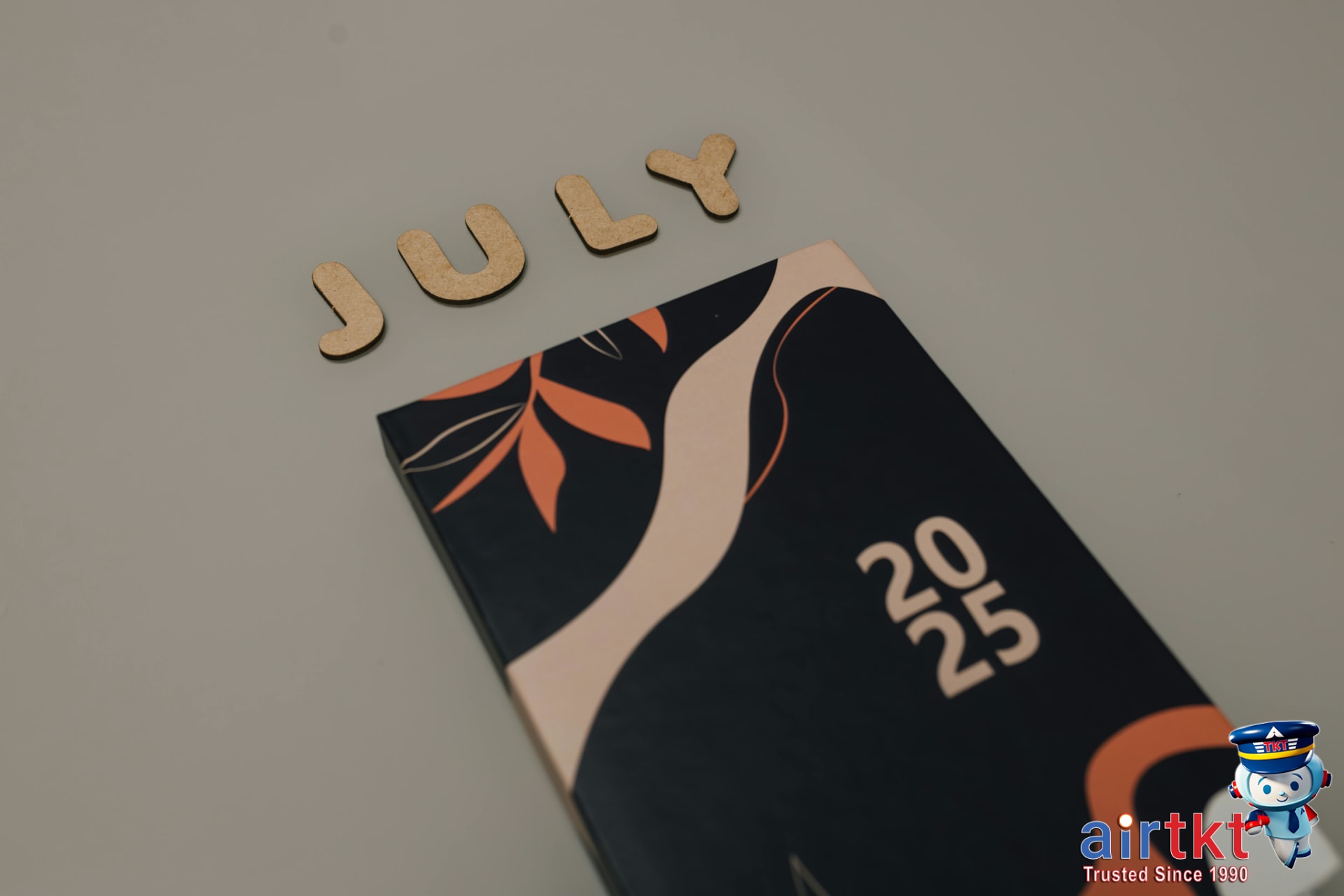 Person using AirTkt platform on laptop to book July travel dates with a calendar