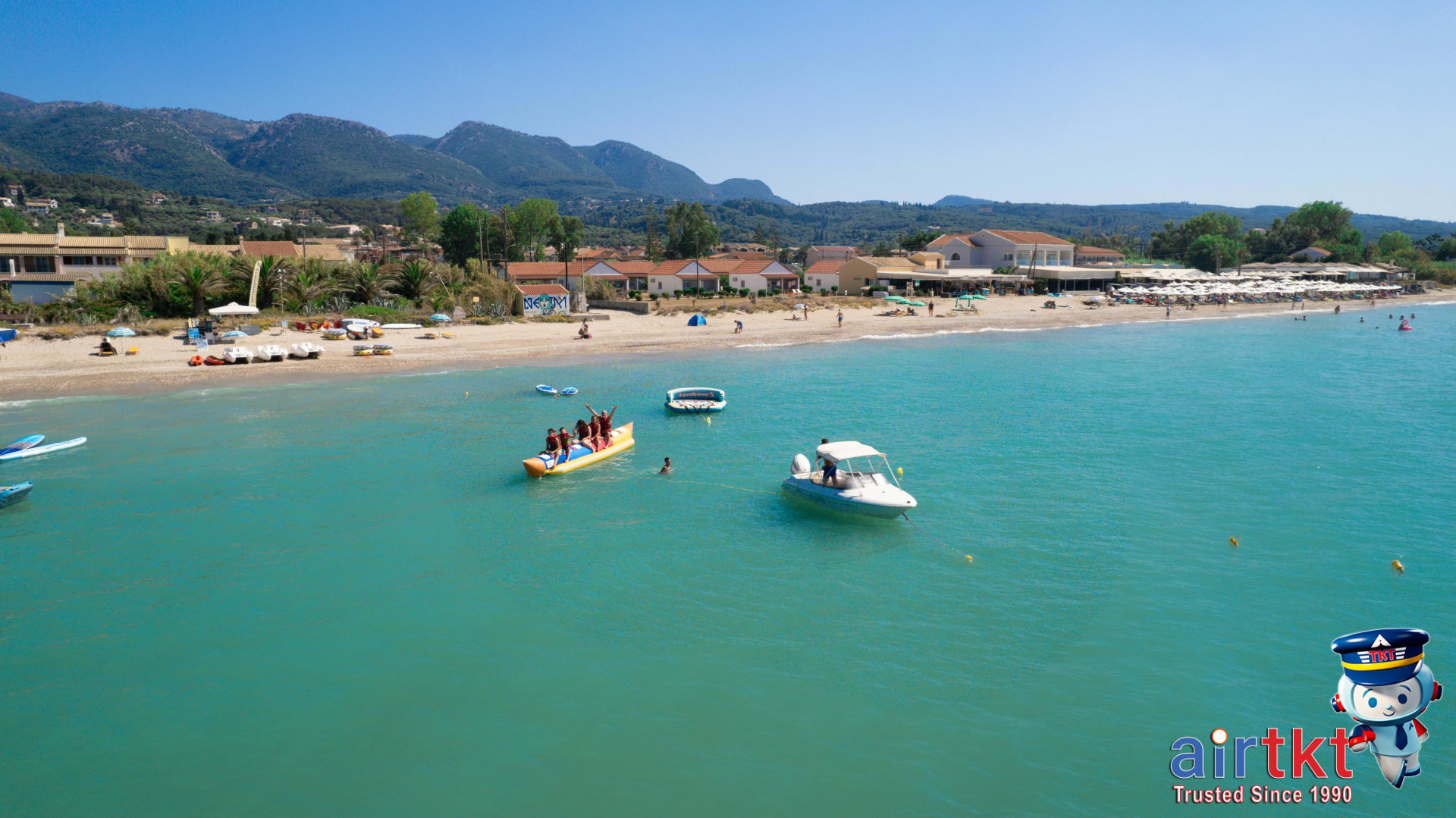 Turquoise sea and vibrant family beach resort enjoying July water activities