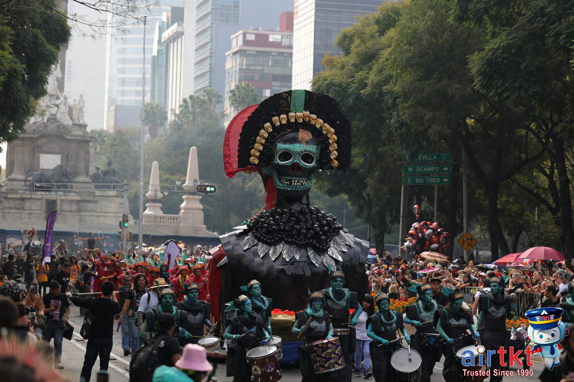 Vibrant Día de Muertos parade in Mexico City streets with dancers and giant puppets