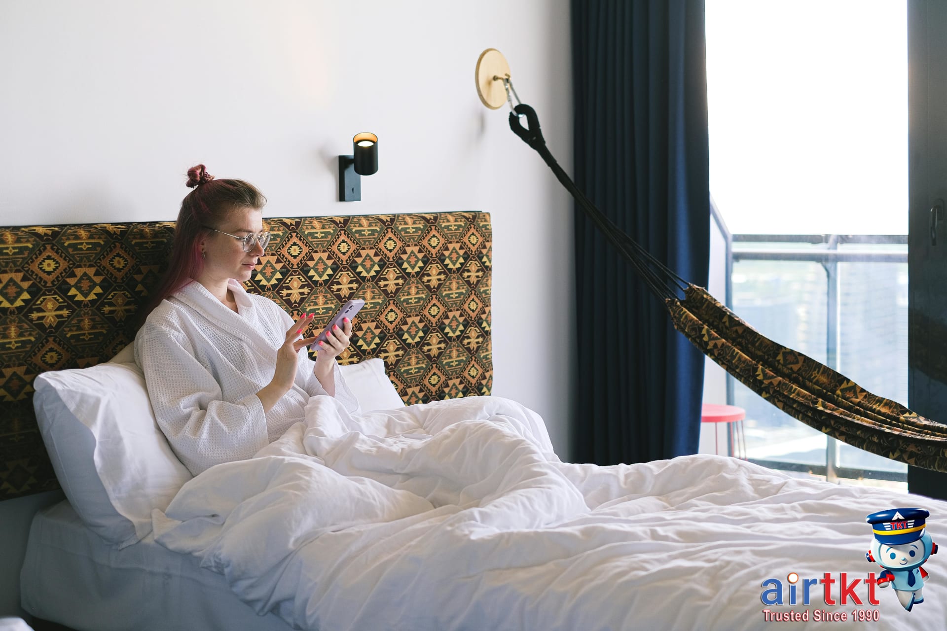 Traveler viewing hotel price matching FAQs on mobile phone in hotel room