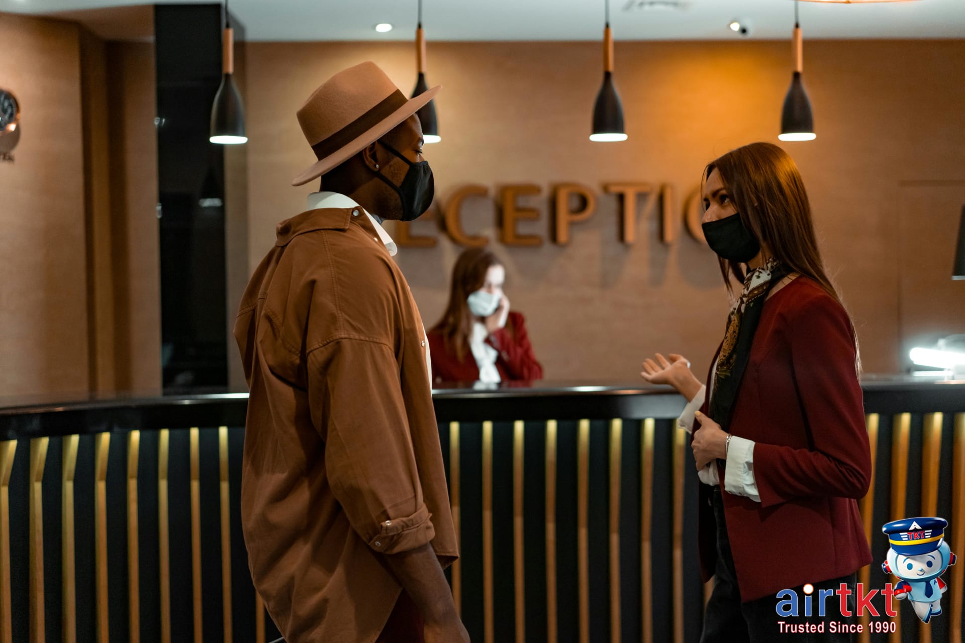 Customer discussing price matching hotel guarantee at lobby desk