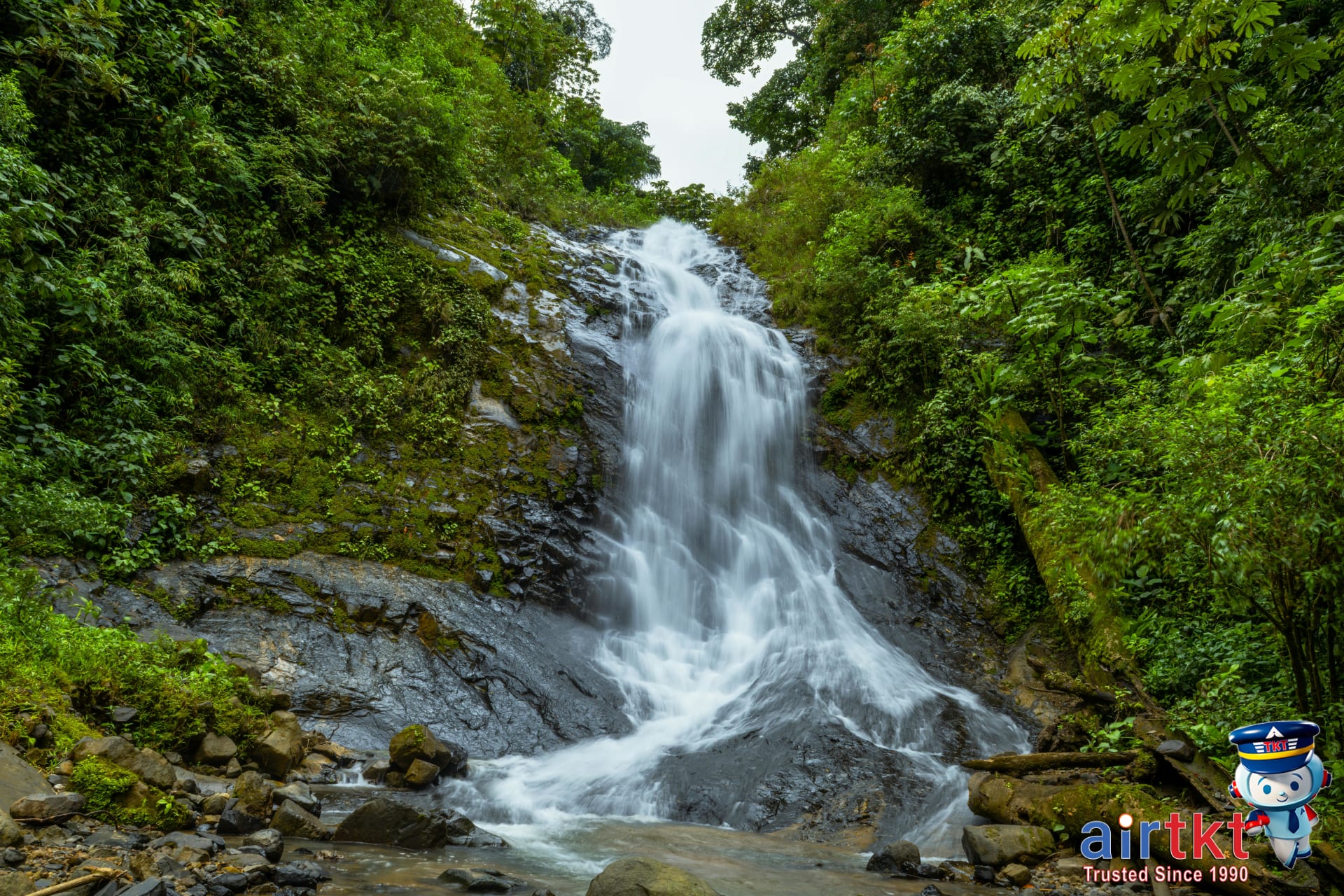 Costa Rica waterfall amid lush green rainy season landscape surrounded by forest