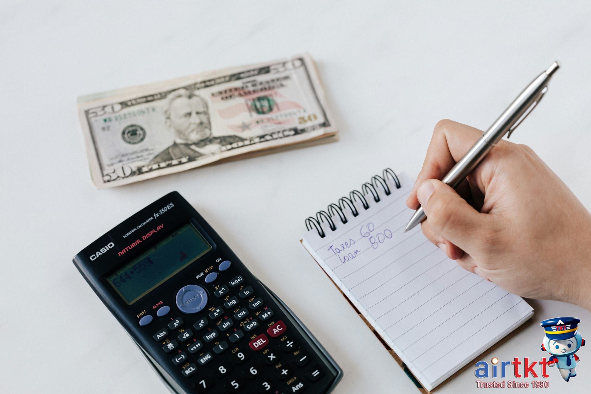 Travel budget planner with calculator and money on wooden desk