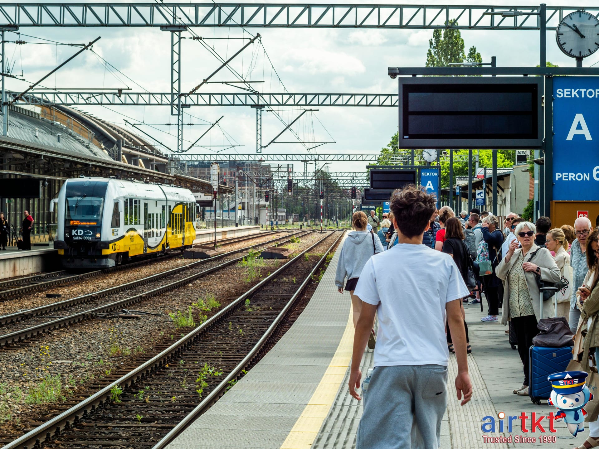 Traveler navigating busy train station platform with many passengers