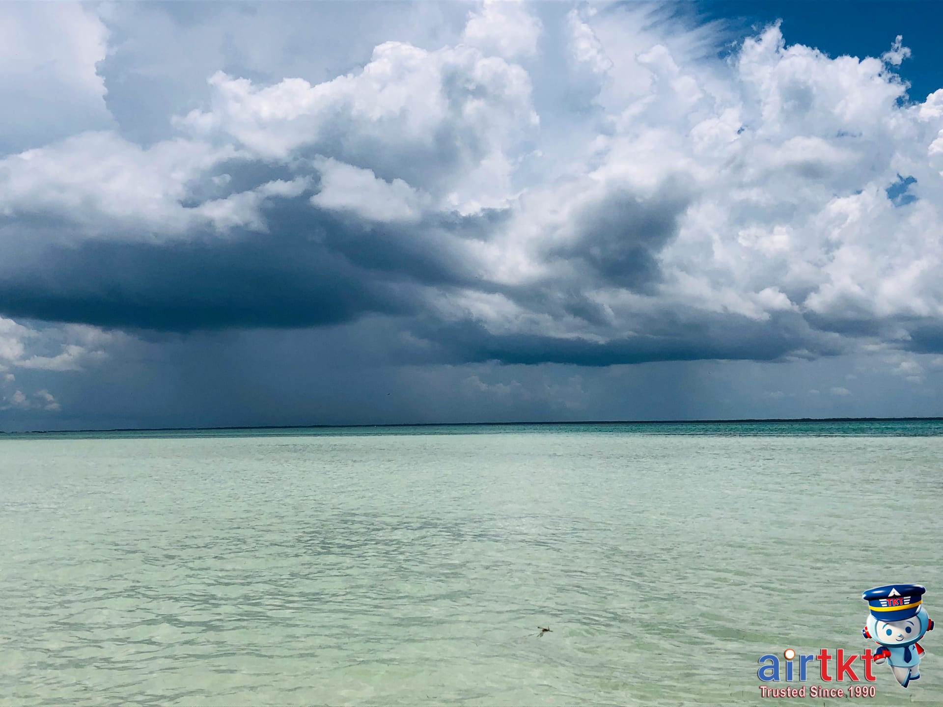 Tropical storm clouds over Caribbean island during hurricane season travel months