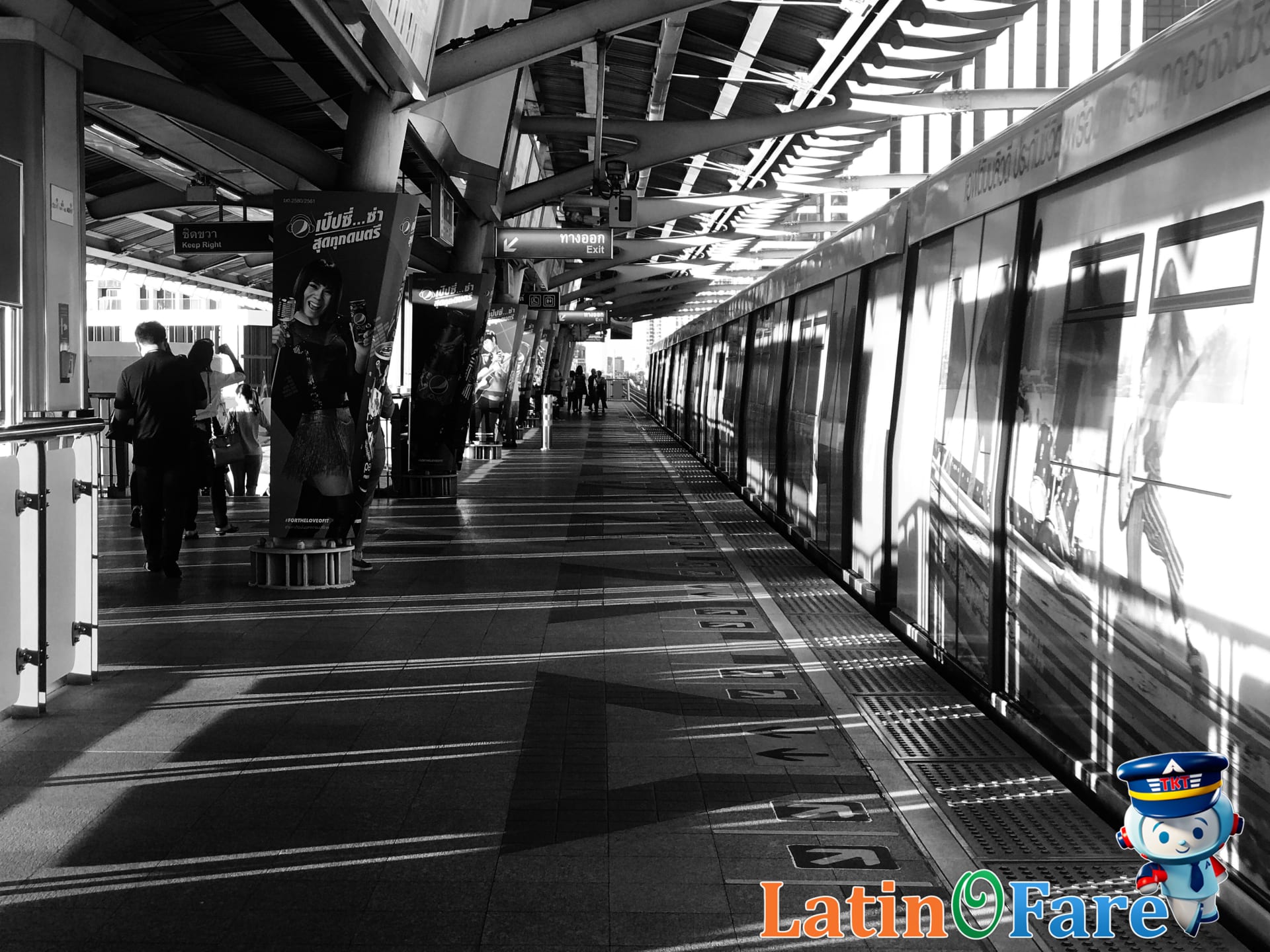 Busy BTS Skytrain platform in central Bangkok showing travelers waiting during peak travel hours.