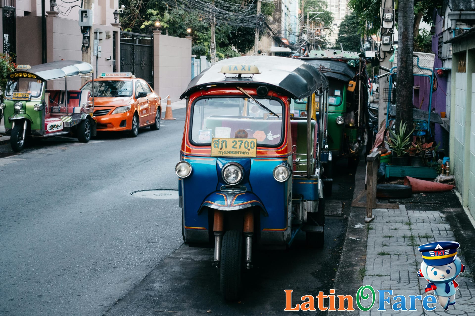 Colorful Bangkok tuk-tuks lined up near market street waiting for local passengers and tourists.