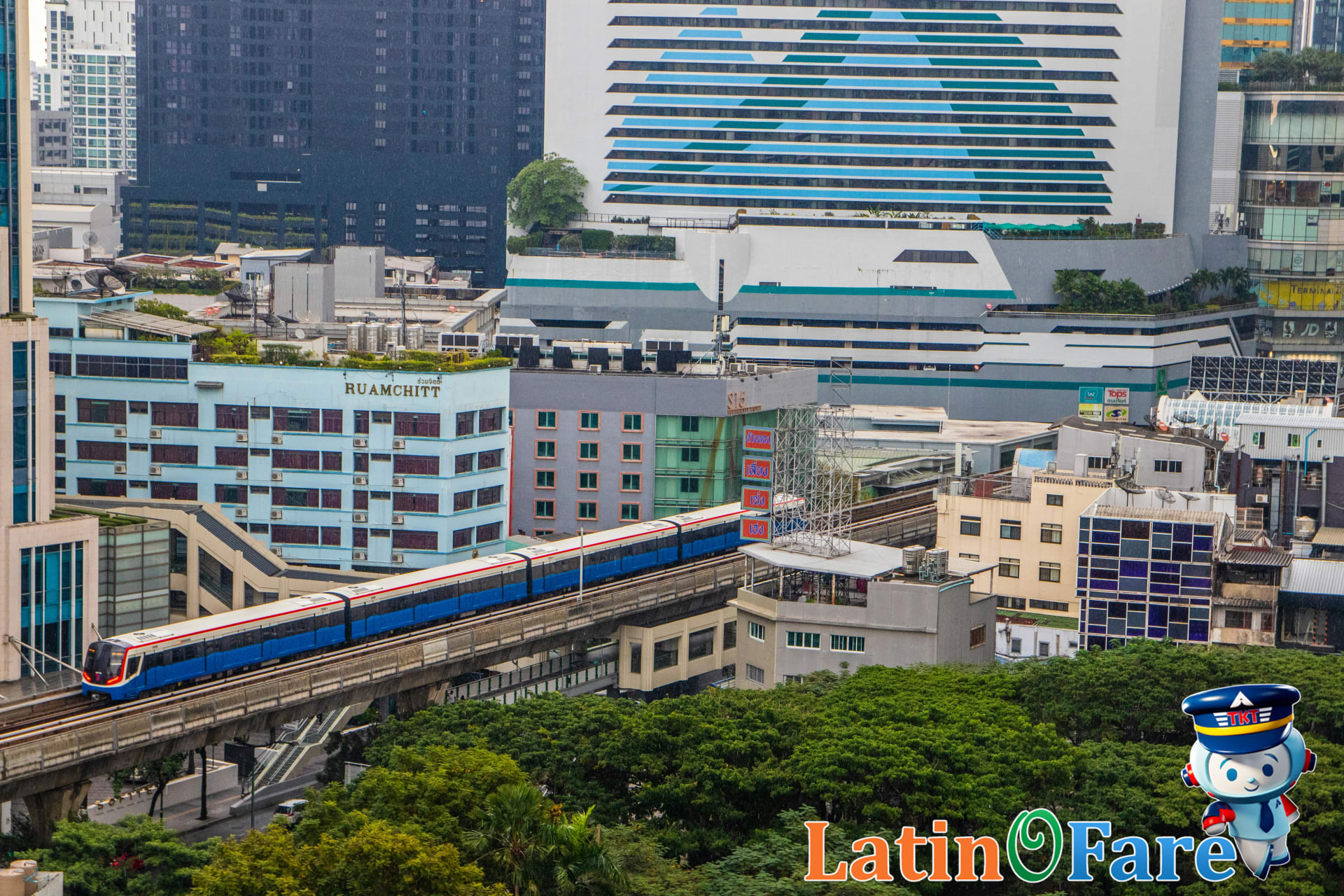 Aerial view of Bangkok BTS Skytrain and river boats in the vibrant city center.