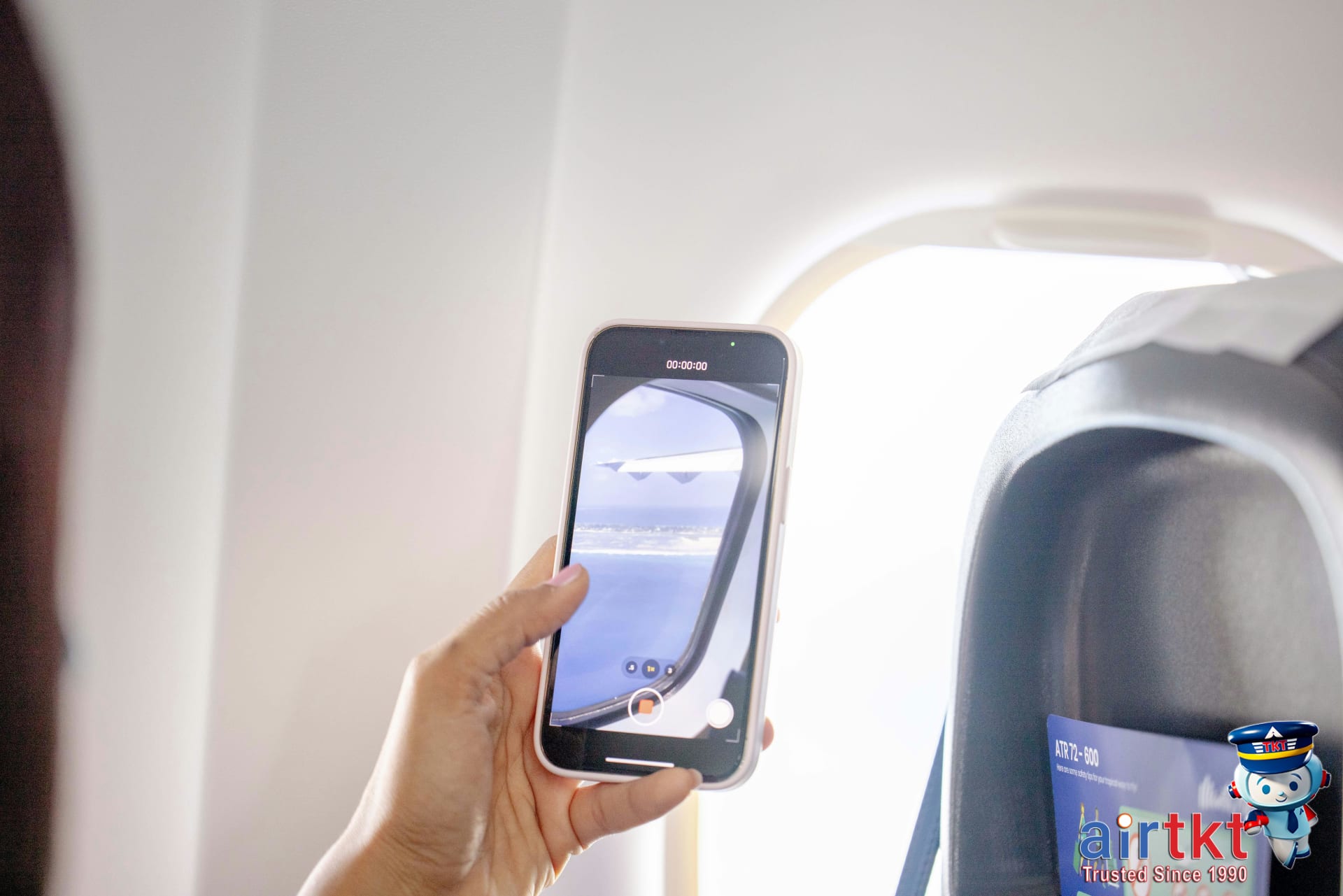 Traveler booking flights on mobile device using AirTkt app happily