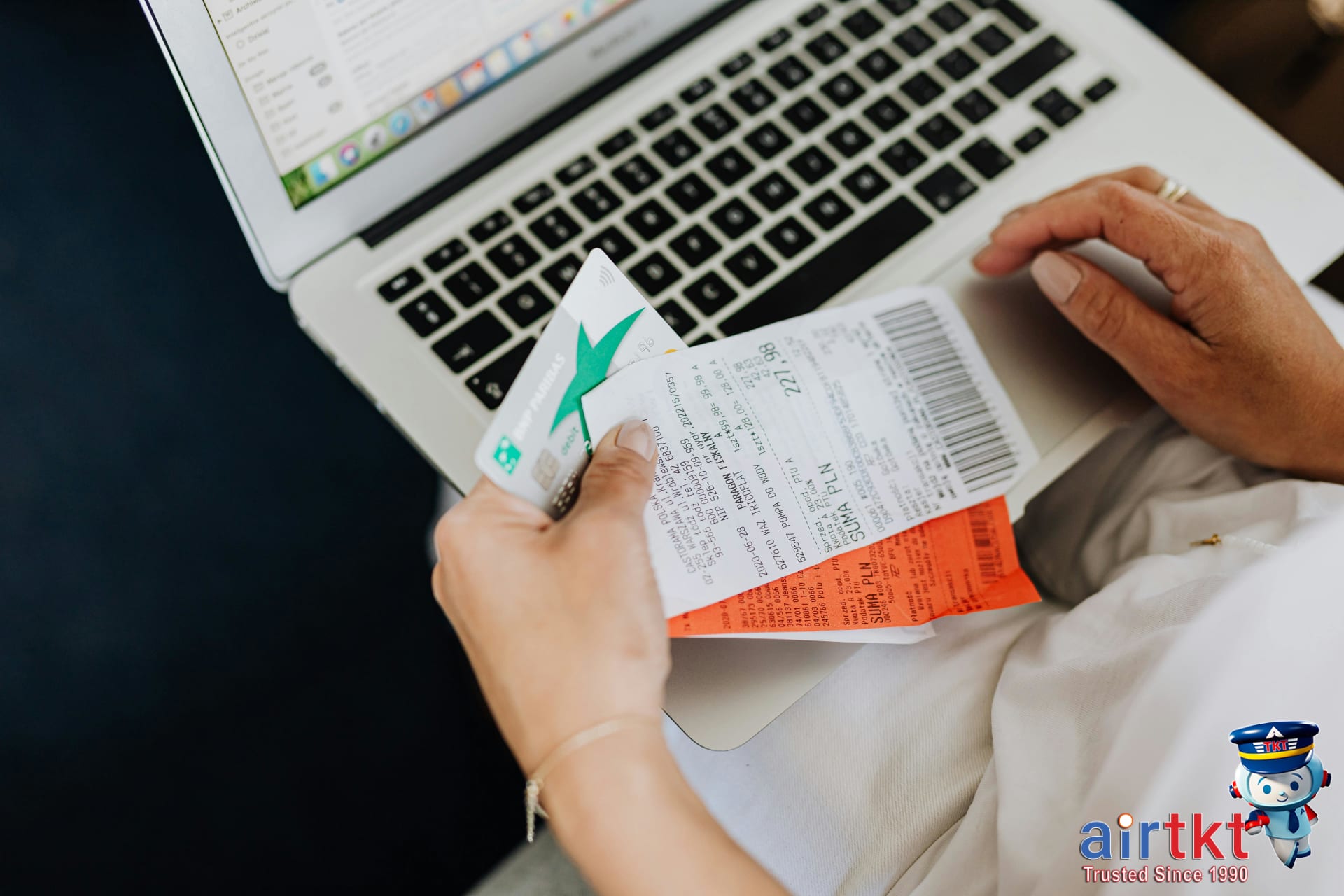 Traveler using a laptop and spreadsheet to budget ATM usage and costs during an international trip