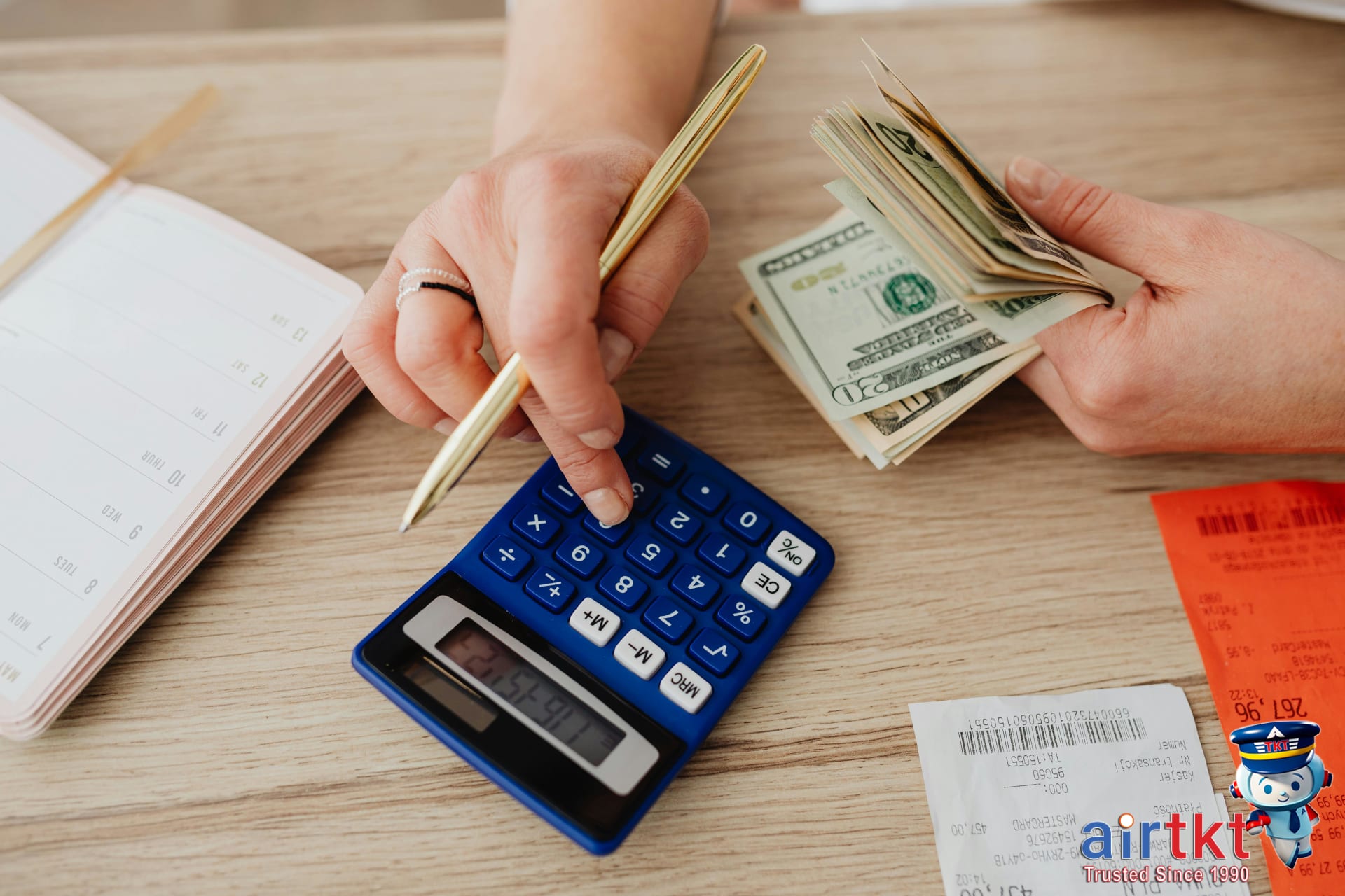 Hands and calculator counting Mexico City travel budget with cash and pen