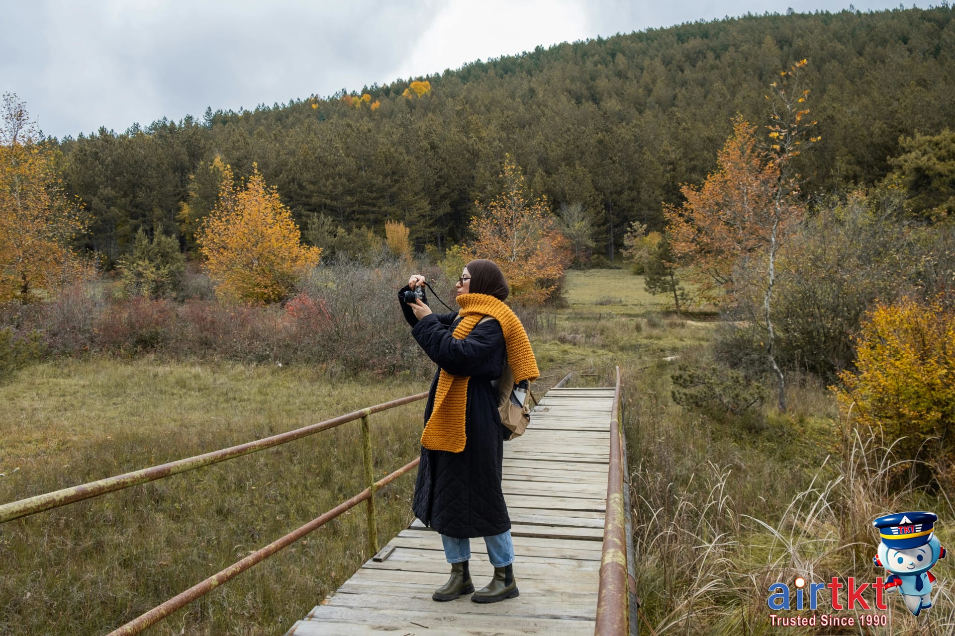 Traveler with camera enjoying colorful fall foliage in New England town park