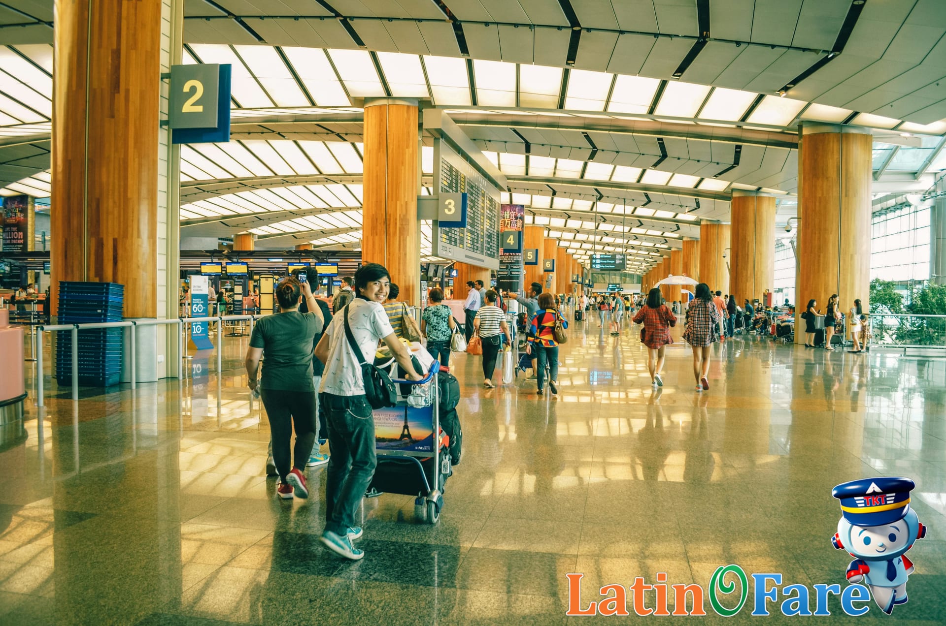 Family navigating airport with kids, handling strollers and backpacks during busy travel moments.