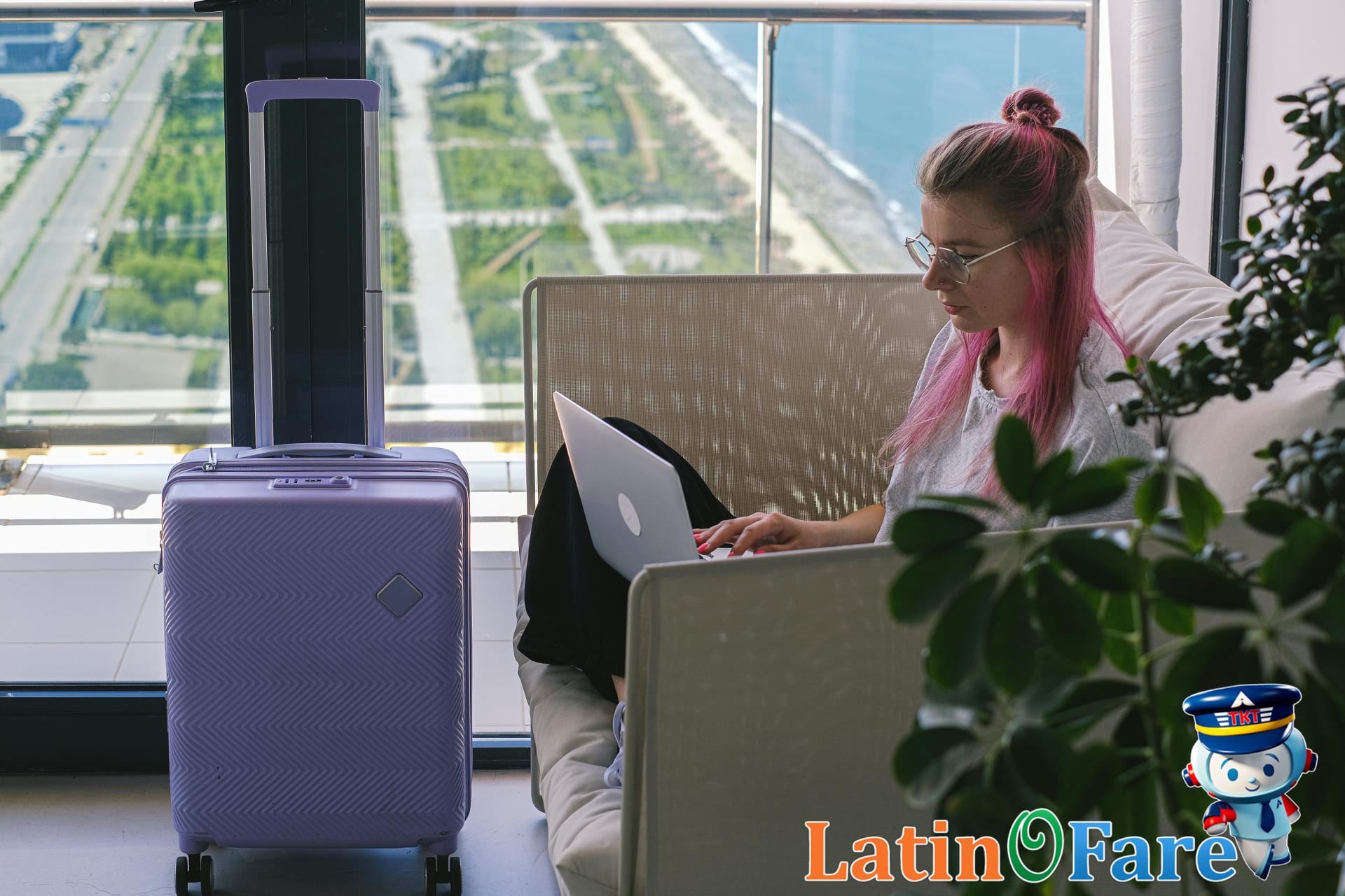 Traveler in hotel room using laptop to redeem loyalty points for free stay