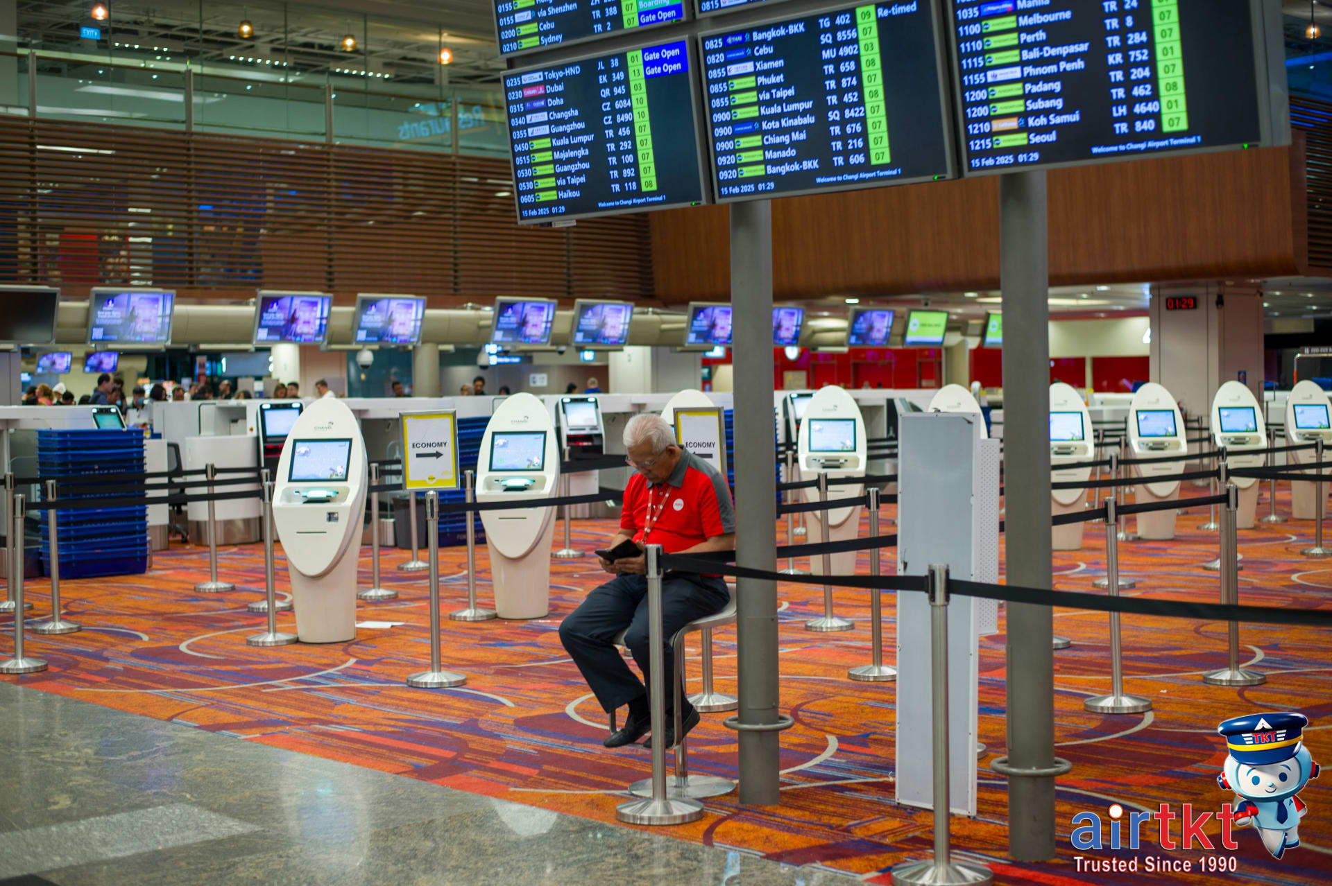 Traveler checking flight apps for multiple airports options in busy airport terminal