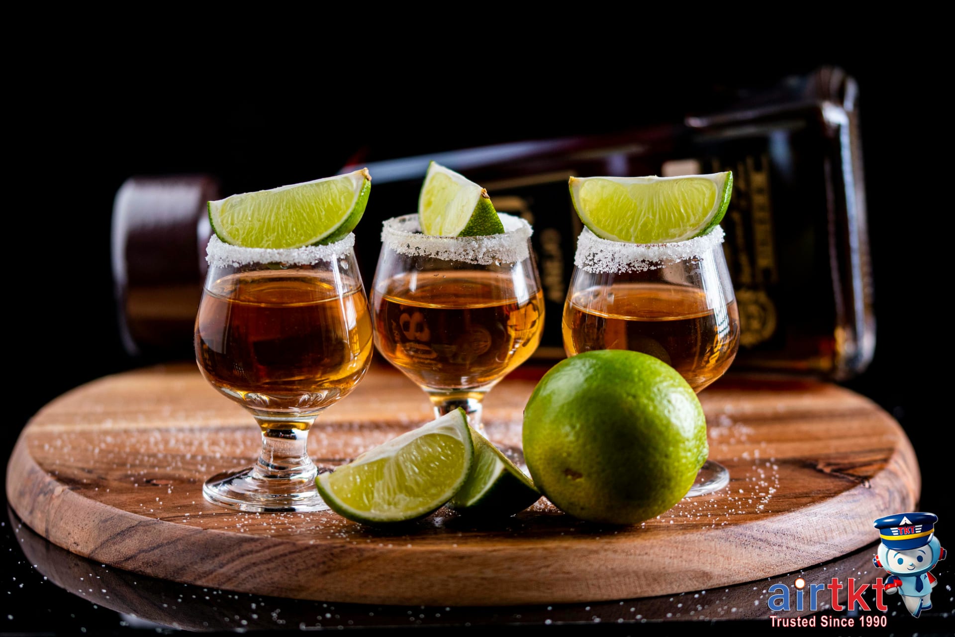 Tequila shots on wooden board with lime and salt at a Mexican tasting event