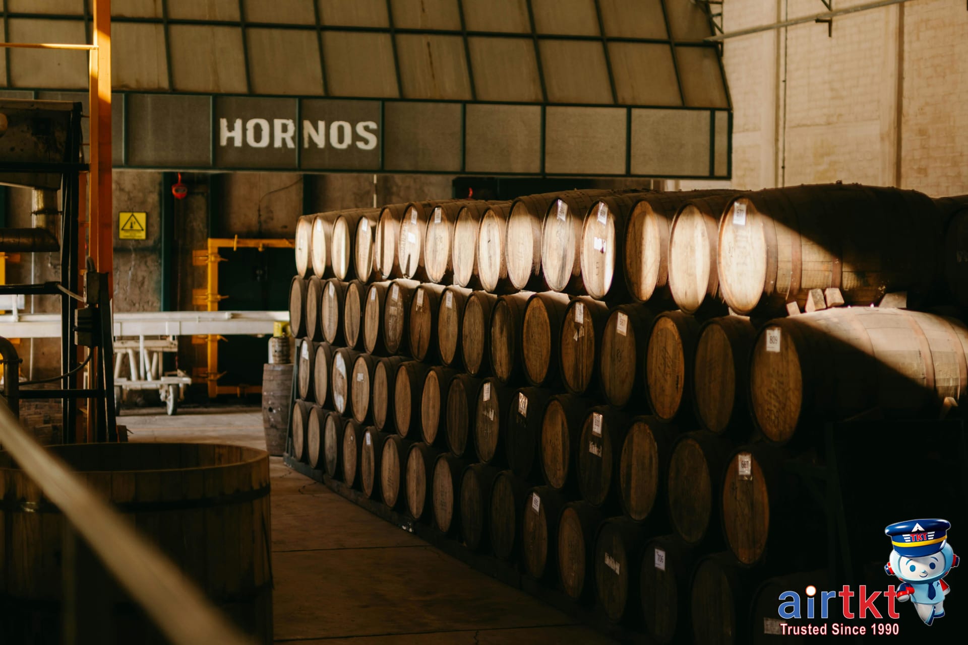 Wooden barrels aging tequila in a traditional Mexican distillery hall in Guadalajara