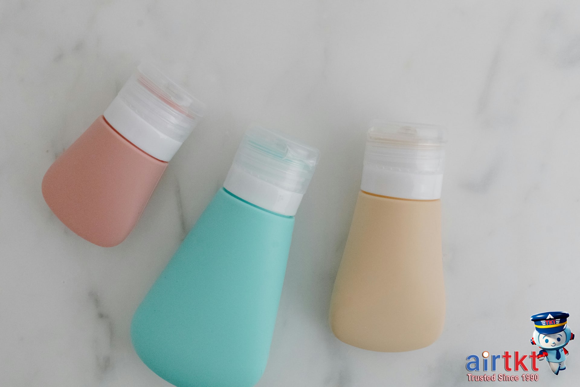 Travel-sized toiletries for carry-on only packing on marble counter