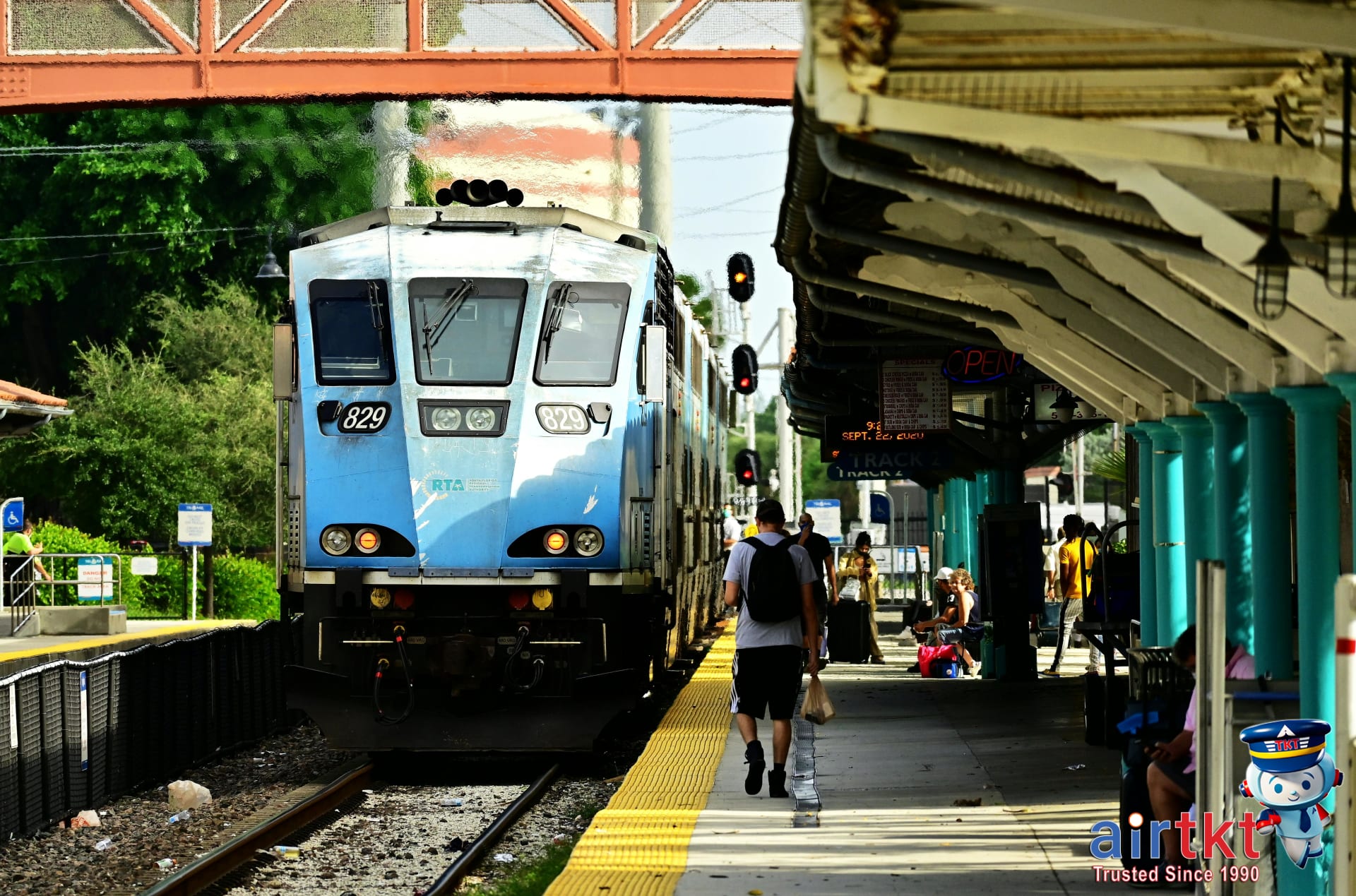 Miami Metrorail train at station with passengers boarding the train during daylight