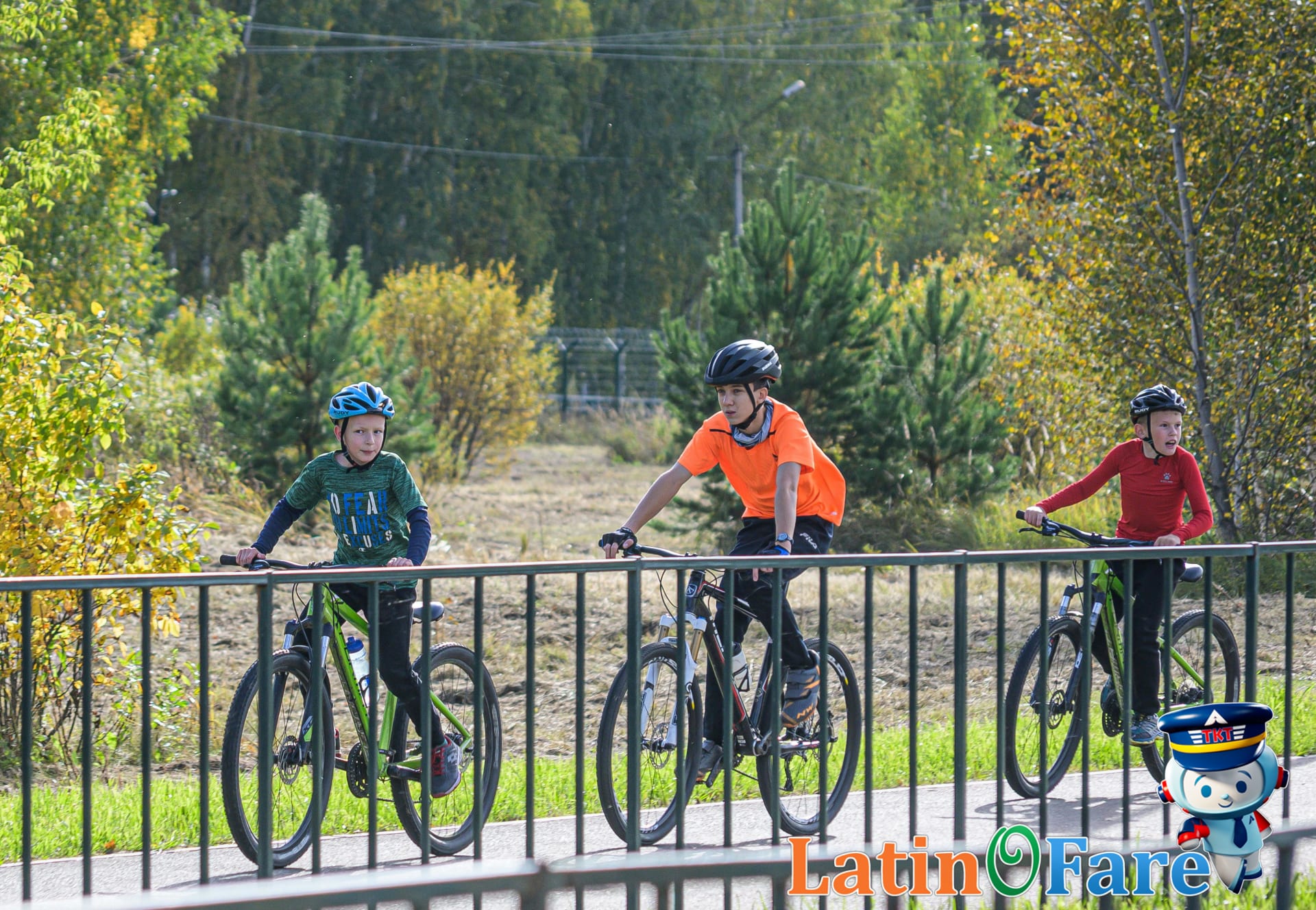 Three children riding bicycles along a sunny park pathway during a Vancouver family vacation.