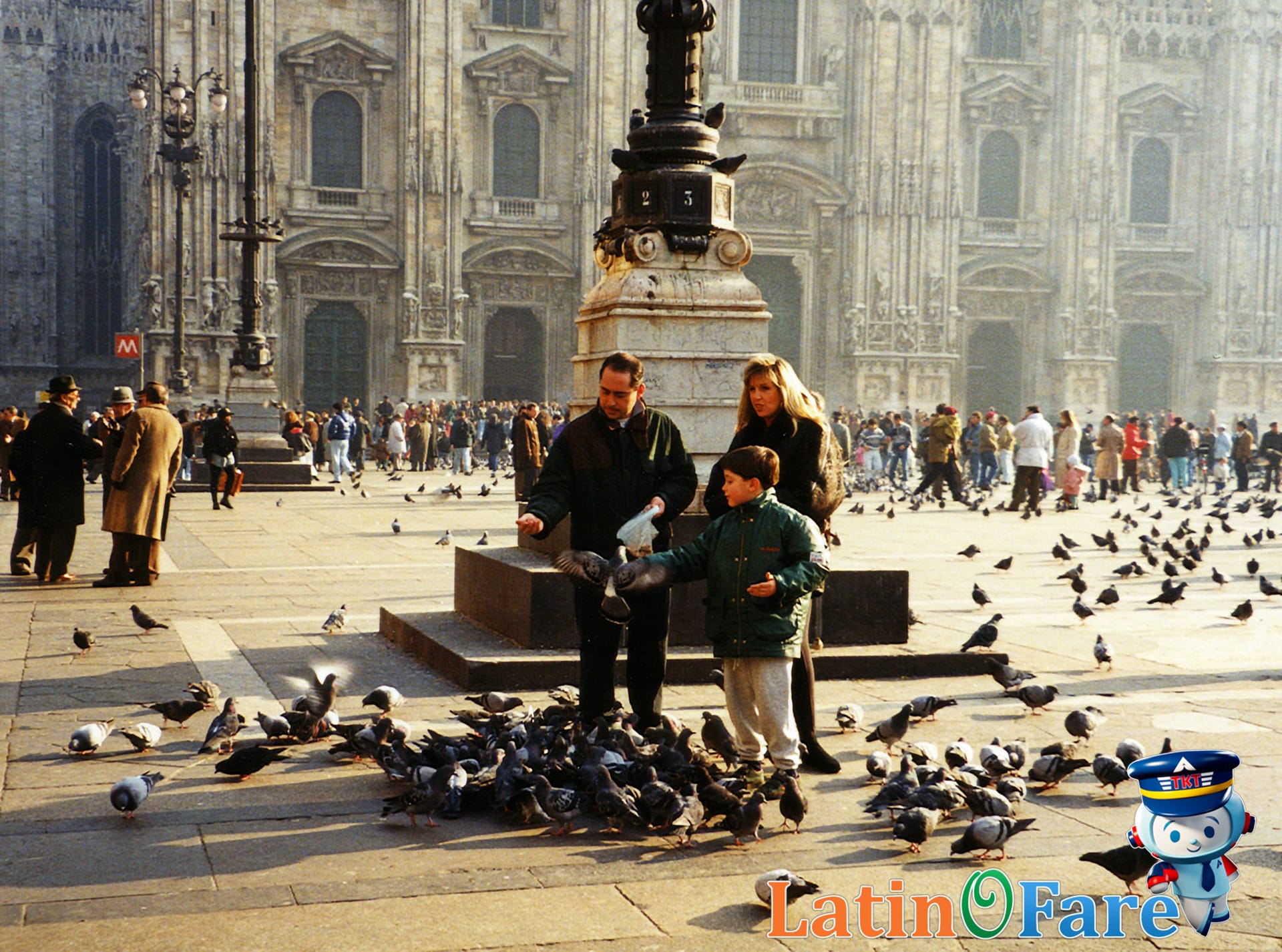 Family feeding pigeons and sightseeing in a historic city square with kids in London.