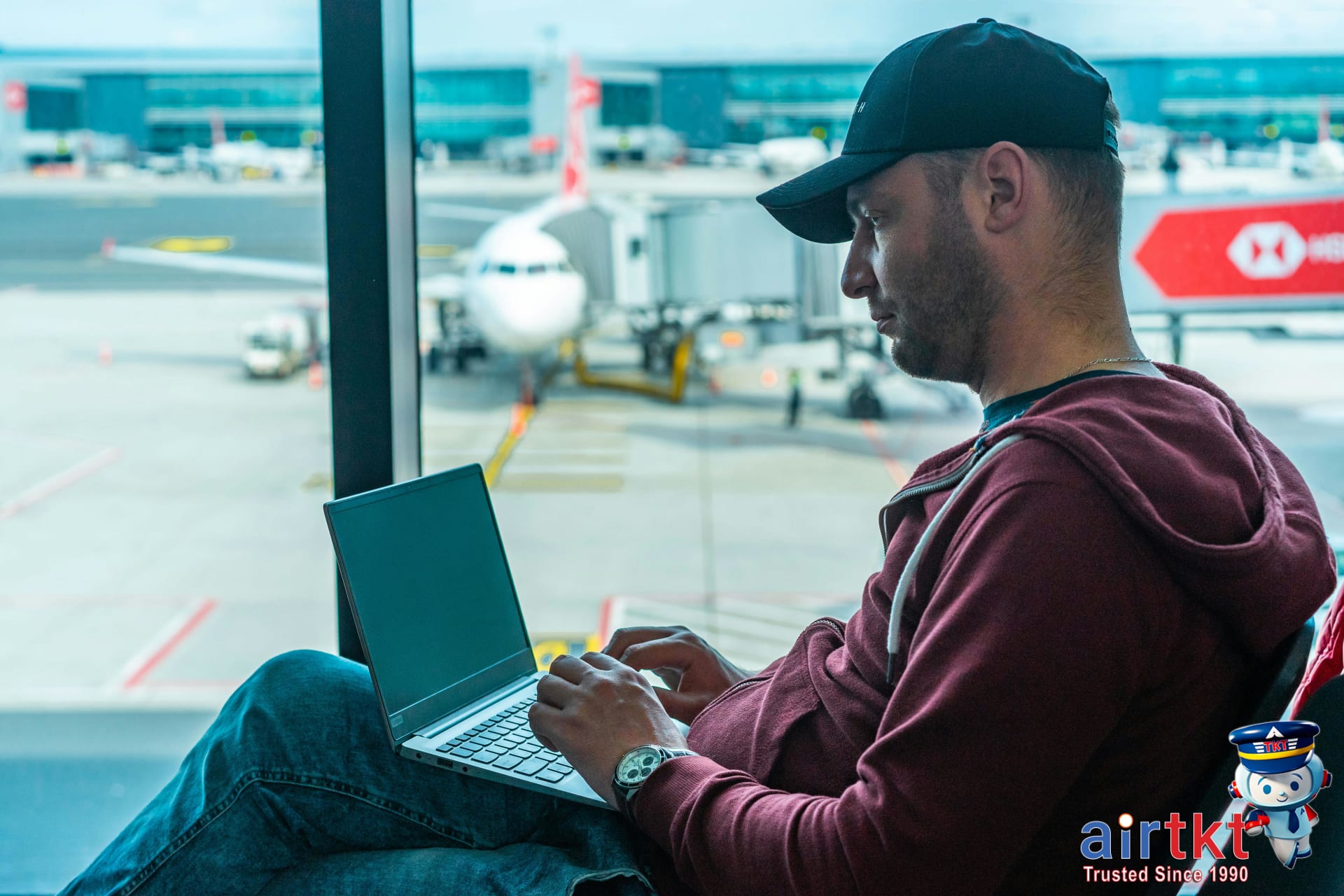 Booking holiday travel on AirTkt platform with traveler using laptop
